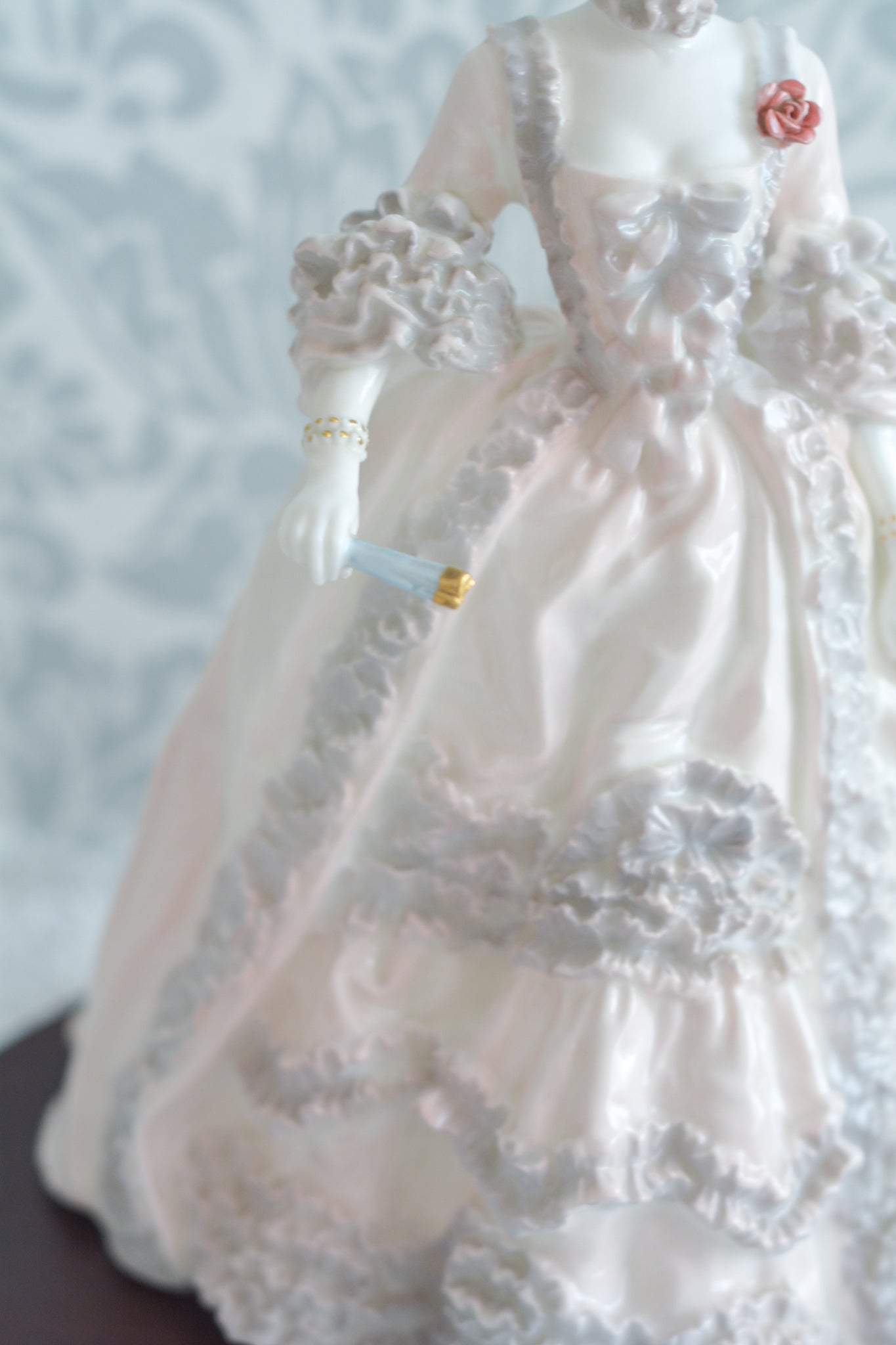 コールポートのポンパドール夫人の美しいフィギュリン。コールポートの中でも一番貴重で人気のフィギュリンではないでしょうか。美しいお顔にグレーとピンクの華やかなドレス。人気があるのも分かります。ポンパドール夫人はその美顔からフランスルイ15世の公式の愛妾となったのは有名な話。美顔だけでなく、頭もとてもよく政治にも積極的に関与しています。色々な側面を持ち合わせますが、芸術を愛し、その発展に大きな影響を与えました。ポンパドール夫人の時代はフランスを中心に優美なロココ様式が流行します。イギリスで1810年〜1830年代頃に流行したロココリバイバルはフランスのロココ様式の影響を受けてイギリスでロココ様式が再流行したものです。そんなポンパドール夫人のフィギュリンは、キャビネットに飾ってもティータイムにテーブルに置いてもどんなシーンでも、パッとスポットライトが当たったかのような存在感です。