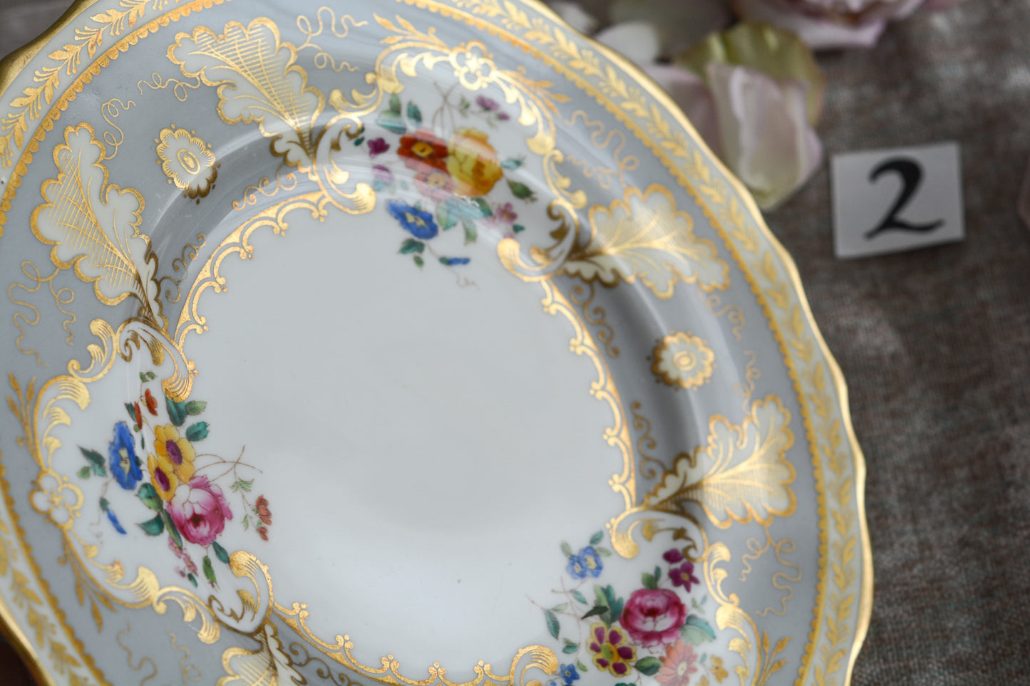 コウルドンのティファニーパターンの素敵なデザートプレートです。ハロッズがオーダーしたもので、ティファニーのスタンプはありませんが、柄はティファニーがコウルドンに特注したパターンです。ティファニーらしい上品な絵柄がとても美しくでコウルドンの中でも人気のシリーズです。当時も人気があったのでしょう。いろいろな小売店がこのパターンをオーダーしています。グレーカラーは柔らかい雰囲気で金彩との相性もいいです。とてもエレガントなプレートです。