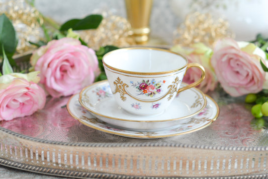 ノリタケの里帰り品のティートリオ。ハンドペイントで描かれた可愛らしいお花に金盛りの金彩の模様もとてもエレガントです。白磁がとても白く美しく気品を感じるお品。クリスマスはもちろんティータイムを華やかに盛り上げてくれるでしょう。