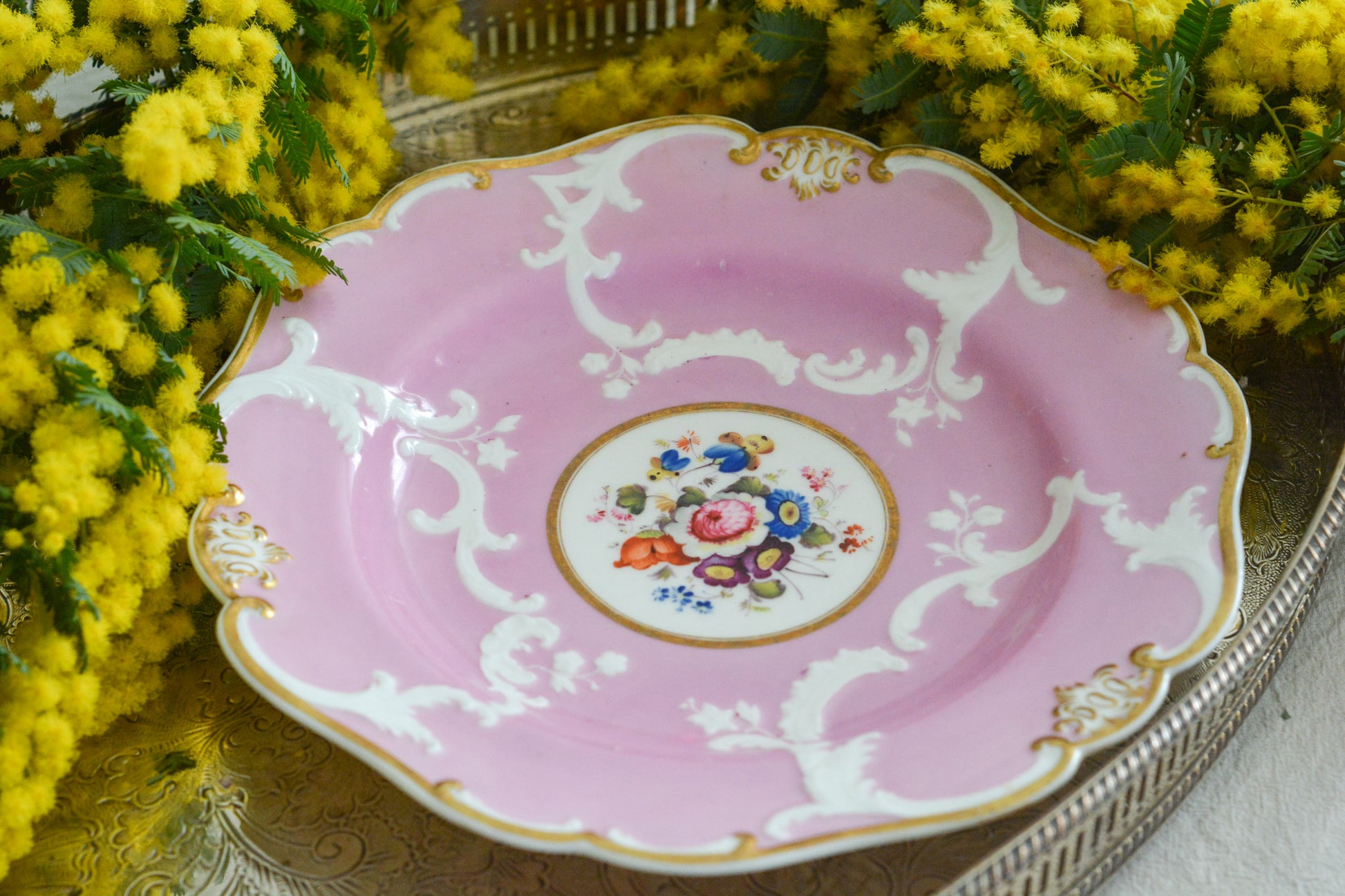 可愛らしいピンクカラーに中央にハンドペイントで丁寧に描かれたブーケの模様が美しいプレートです。エンボスの模様も優雅でチョコレートや小さな焼き菓子、パンどんなものを盛り付けても品よくまとまりそうです。一ヶ所小さなヘアラインがあるためお値打ち価格になっています。