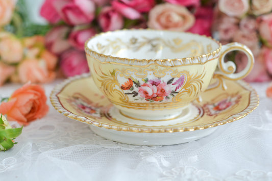 コールポートのペンブロークシェイプと呼ばれるシェイプのカップです。縁の飾り模様が特徴的で1820年代後半に作られたとても古い作品です。豪華な縁飾りに手描きで描かれた美しい花々、エレガントなリングハンドル。約200年前に作られ、この持ち主の貴族はこんな美しいカップでどんな優雅なティータイムを過ごしていたのでしょうか。