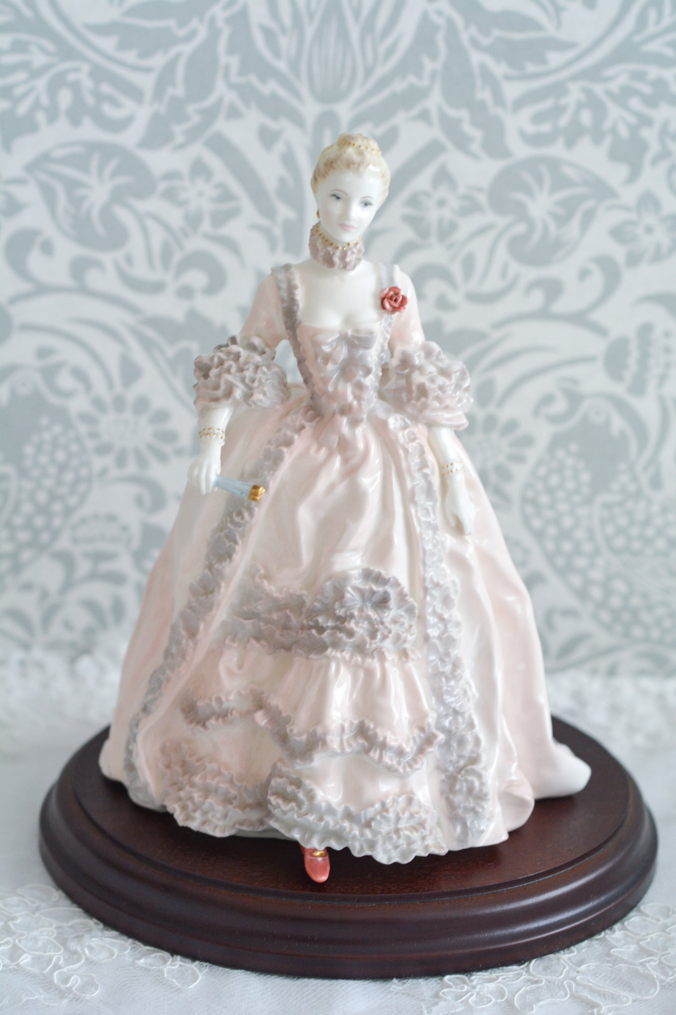 コールポートのポンパドール夫人の美しいフィギュリン。コールポートの中でも一番貴重で人気のフィギュリンではないでしょうか。美しいお顔にグレーとピンクの華やかなドレス。人気があるのも分かります。ポンパドール夫人はその美顔からフランスルイ15世の公式の愛妾となったのは有名な話。美顔だけでなく、頭もとてもよく政治にも積極的に関与しています。色々な側面を持ち合わせますが、芸術を愛し、その発展に大きな影響を与えました。ポンパドール夫人の時代はフランスを中心に優美なロココ様式が流行します。イギリスで1810年〜1830年代頃に流行したロココリバイバルはフランスのロココ様式の影響を受けてイギリスでロココ様式が再流行したものです。そんなポンパドール夫人のフィギュリンは、キャビネットに飾ってもティータイムにテーブルに置いてもどんなシーンでも、パッとスポットライトが当たったかのような存在感です。