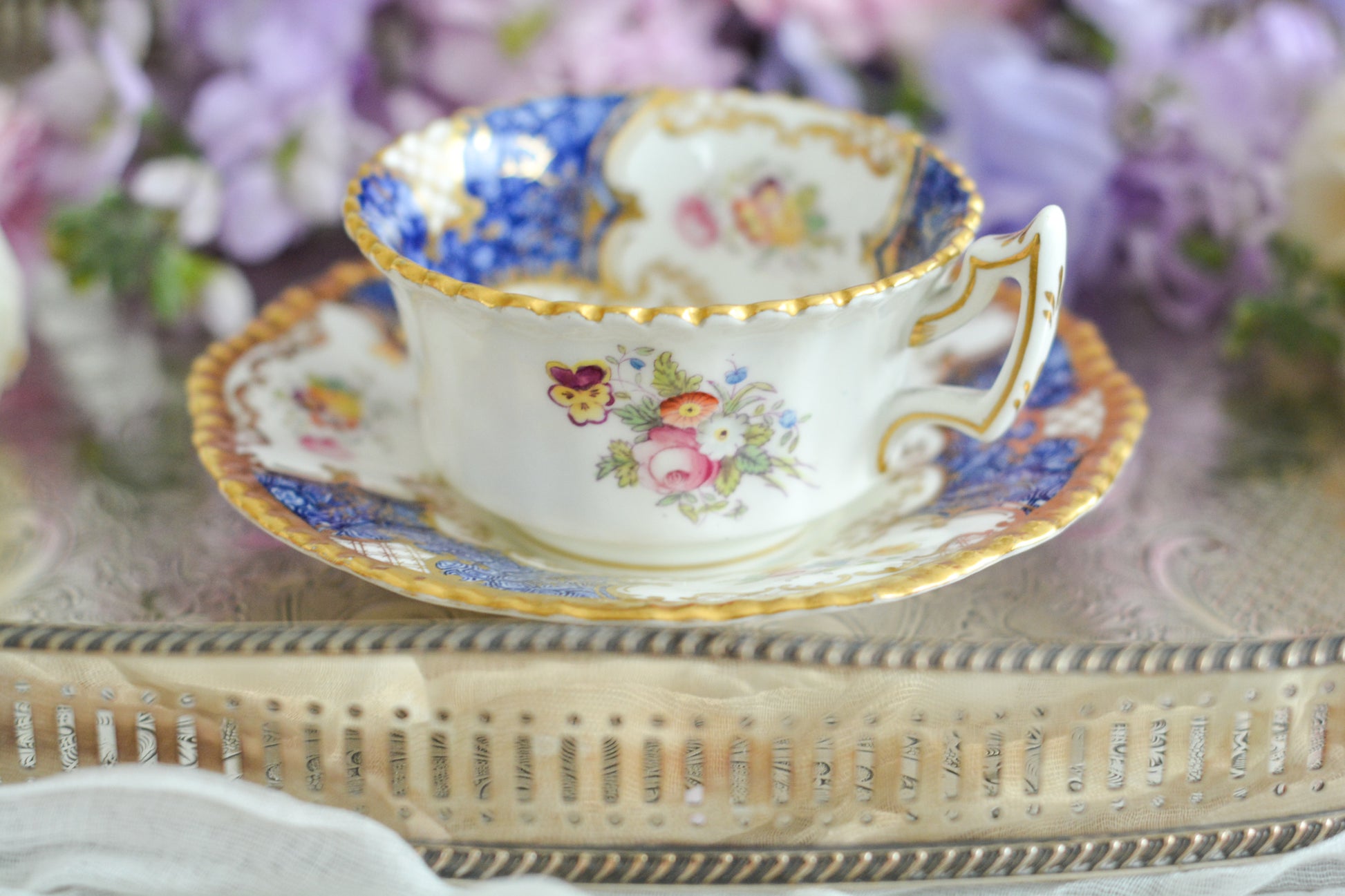 コールポートの人気シリーズ、バットウィングシリーズ。とても珍しい模様のデュオが入荷しました。鮮やかなブルーカラーの年輪のような模様がとても美しいお品です。カップのサイドにはエナメルのお花たちが描かれています。以前色違いの淡いグリーンをご紹介したことがあります。こちらは、カップに製造時にできたと思われる小さな穴があります。貫通はしていないのですが、そこだけ油薬がかかっていません。その穴付近にごく微細な貫入が1つあります。 その他は貫入もなく、金彩もとても綺麗に残っていて、キラキラと輝いています。特別なバットウィング。プレゼントにもご自身のご褒美にもぴったりなお品です。