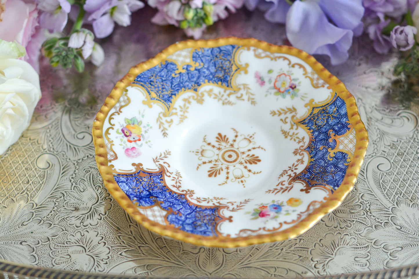 コールポートの人気シリーズ、バットウィングシリーズ。とても珍しい模様のデュオが入荷しました。鮮やかなブルーカラーの年輪のような模様がとても美しいお品です。カップのサイドにはエナメルのお花たちが描かれています。以前色違いの淡いグリーンをご紹介したことがあります。こちらは、カップに製造時にできたと思われる小さな穴があります。貫通はしていないのですが、そこだけ油薬がかかっていません。その穴付近にごく微細な貫入が1つあります。 その他は貫入もなく、金彩もとても綺麗に残っていて、キラキラと輝いています。特別なバットウィング。プレゼントにもご自身のご褒美にもぴったりなお品です。