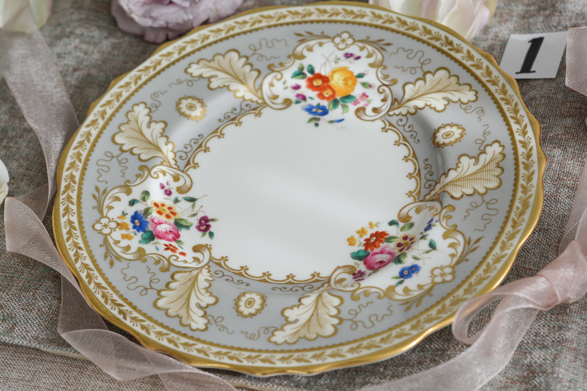 コウルドンのティファニーパターンの素敵なデザートプレートです。ハロッズがオーダーしたもので、ティファニーのスタンプはありませんが、柄はティファニーがコウルドンに特注したパターンです。ティファニーらしい上品な絵柄がとても美しくでコウルドンの中でも人気のシリーズです。当時も人気があったのでしょう。いろいろな小売店がこのパターンをオーダーしています。グレーカラーは柔らかい雰囲気で金彩との相性もいいです。とてもエレガントなプレートです。