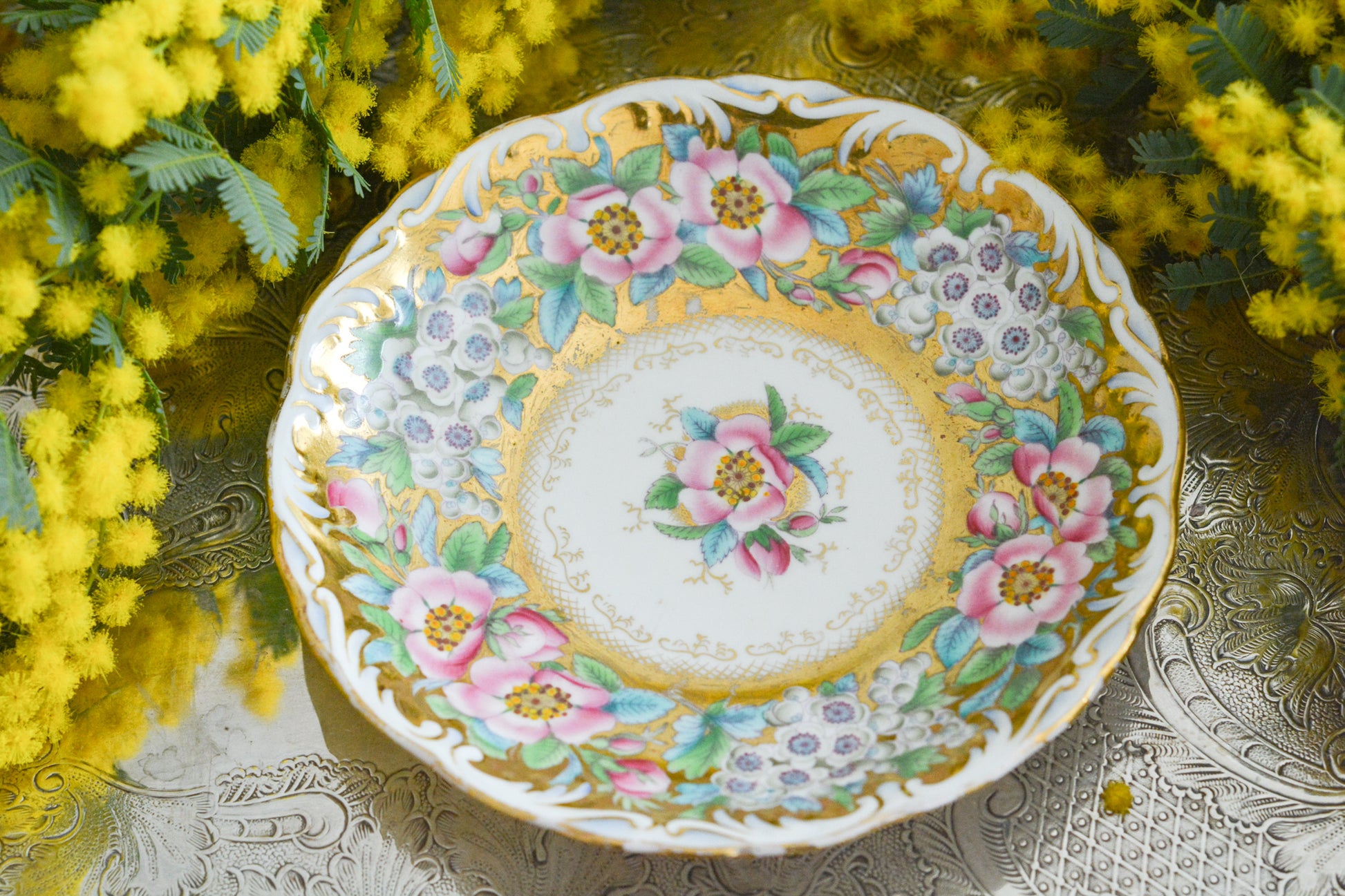 コールポートのロココリバイバル作品の人気のシェイプ、アデレードシェイプ。いろいろなデザインが作られていていますが、こちらのデザインは初めて見ました。ハンドペイントで描かれたお花は野ばらでしょうか?とても華やかなお品です。こちらは元々ティーカップとコーヒーカップ、ソーサーのセットだったと思われますが、コーヒーカップとソーサーのセットになっています。美しいお花がたくさん咲いたような美しいカップと共に春のティータイムをお楽しみください。