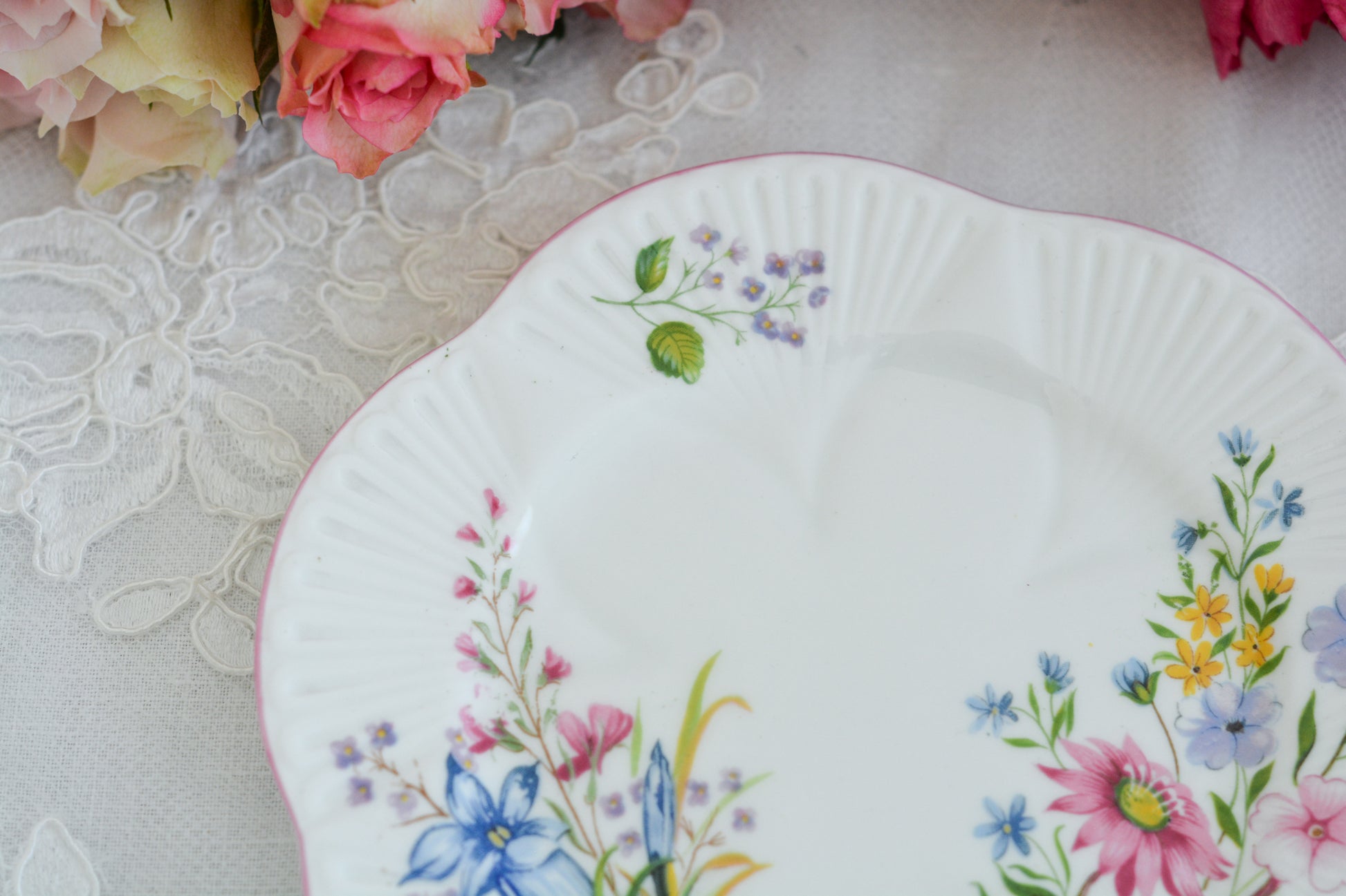 シェリーのワイルドフラワーシリーズの可愛らしいティートリオです。カップはディンティーシェイプと呼ばれる可愛らしいシェイプで上から見るとお花が咲いている様に見えます。イギリスの色とりどりの野花が散りばめられていて、どんな花がプリントされているか眺めるのも楽しいです。こちらは同じシリーズのピンクのお揃いのB&Bプレート、色違いのブルーのB&Bプレートも別で掲載しています。