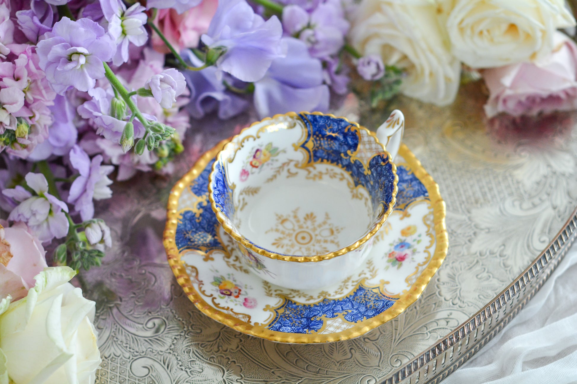 コールポートの人気シリーズ、バットウィングシリーズ。とても珍しい模様のデュオが入荷しました。鮮やかなブルーカラーの年輪のような模様がとても美しいお品です。カップのサイドにはエナメルのお花たちが描かれています。以前色違いの淡いグリーンをご紹介したことがあります。こちらは、カップに製造時にできたと思われる小さな穴があります。貫通はしていないのですが、そこだけ油薬がかかっていません。その穴付近にごく微細な貫入が1つあります。 その他は貫入もなく、金彩もとても綺麗に残っていて、キラキラと輝いています。特別なバットウィング。プレゼントにもご自身のご褒美にもぴったりなお品です。