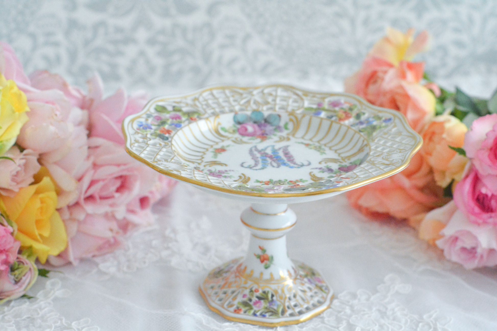 カール・ティーメ工房の花文字でマリーアントワネットの頭文字MとAが描かれた美しいコンポートです。透かし模様のお花や金彩もハンドペイントで丁寧に描かれています。豪華な雰囲気がマリーアントワネットの世界観にぴったりなお品です。ちょっと小ぶりなコンポートで、小さな焼き菓子やチョコレートなどを盛り付けても素敵ですね。マリーアントワネットのプレートも貴重ですが、コンポートはさらに見つけるのが困難なお品です。