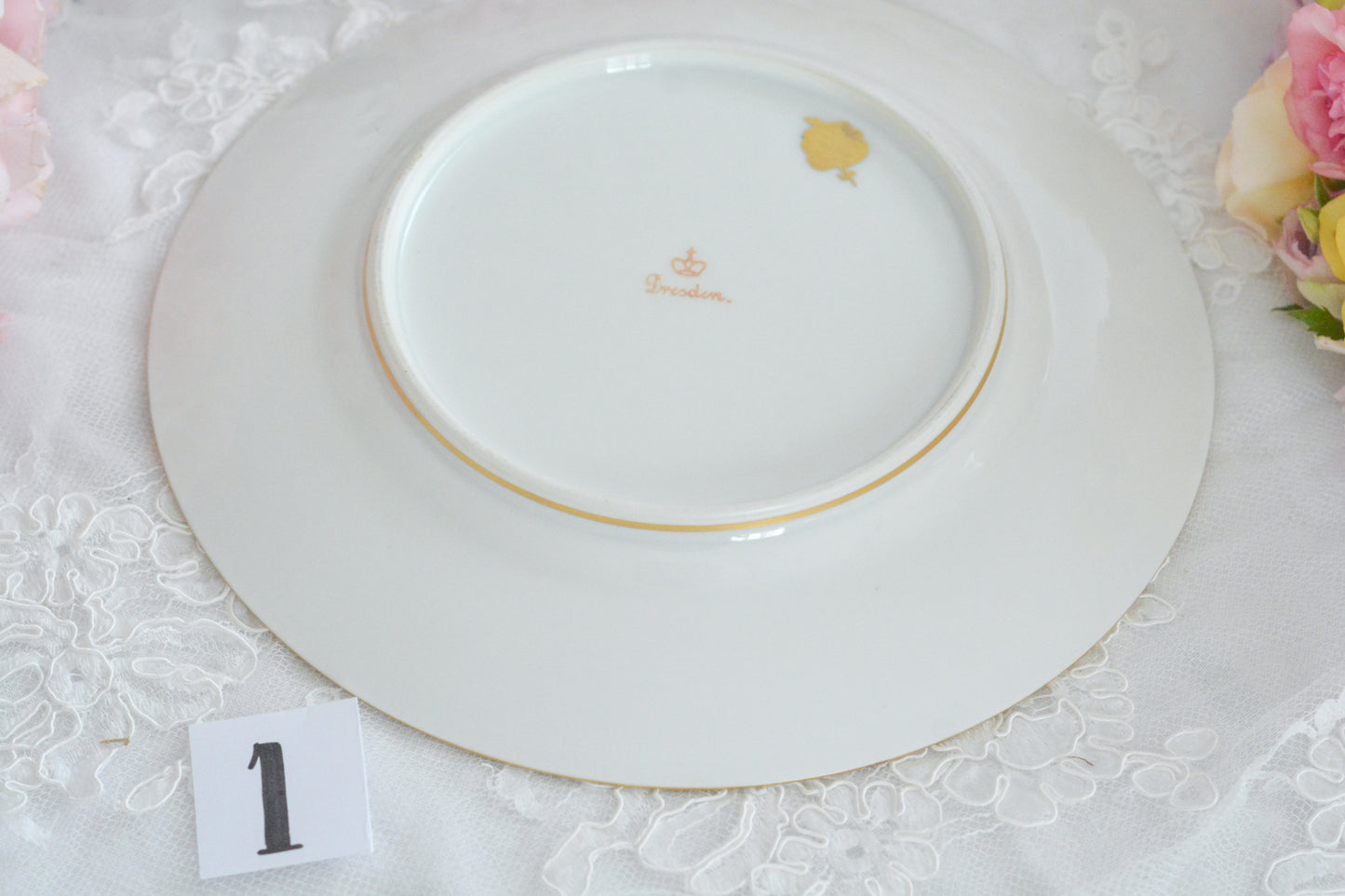 こちらのプレート達はドレスデンの工房で作られてはいますが、カール・ティーメ工房の作品ではありません。特に美しいので特集コーナーに入れさせていただきました。ハンドペイントで描かれた美しい花々に金彩の葉っぱの模様のような縁取りが豪華なお品。金盛りのドットがより花を添えています。キャビネットプレートとしても実際にお使いいただいても素敵なお品です。バックスタンプは1883年〜1893年頃に使われていた王冠マークで、いくつかの工房が集まって使用していました。バックスタンの上には金彩でお花が描かれています。