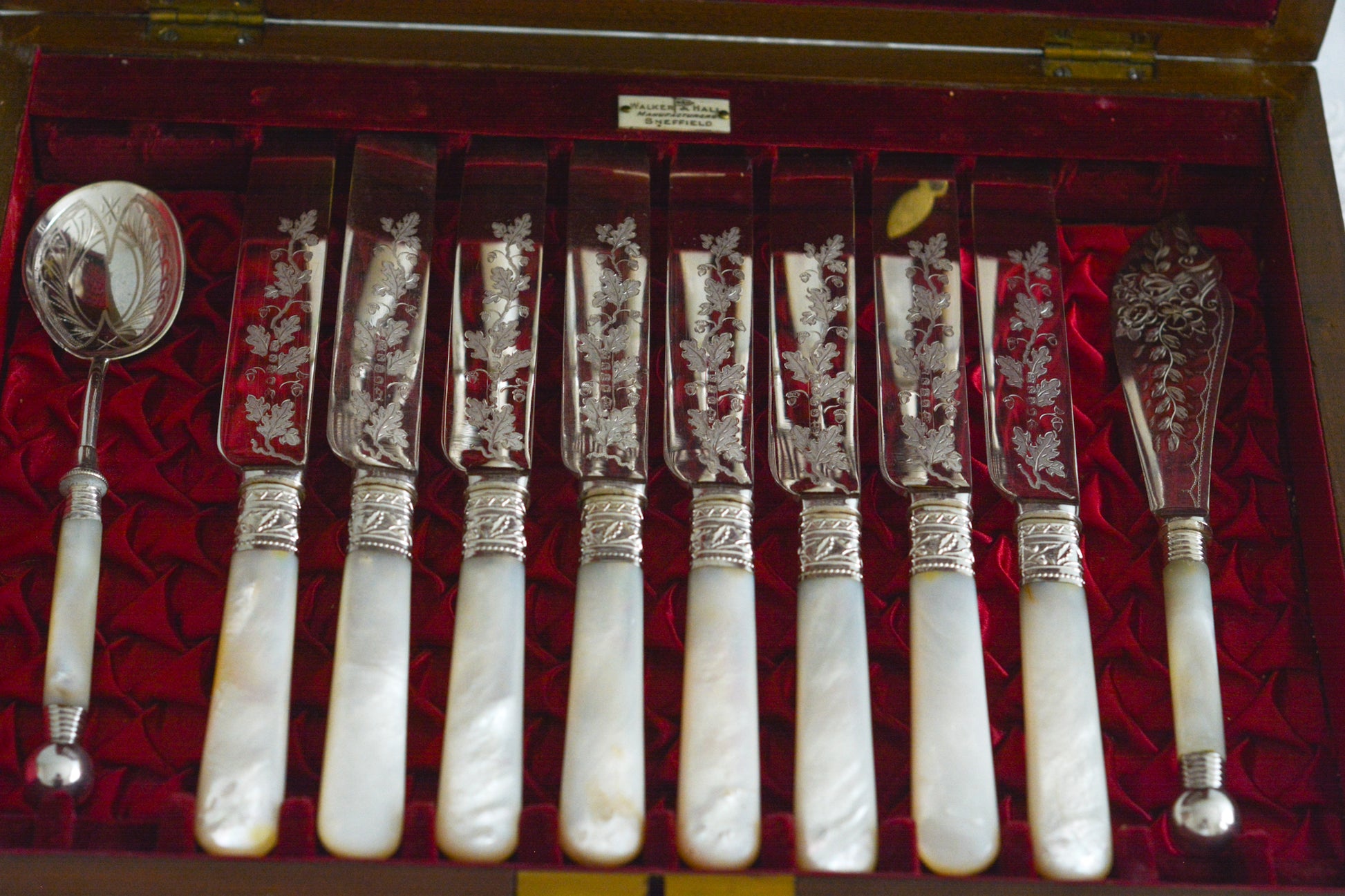 オークの木箱に入った白蝶貝ハンドルのカトラリーセット。元はフォーク&ナイフ12組のセットだったと思いますが今は8組のセットになっていて、同じシリーズではありませんが、サービングスプーンとサービングナイフがセットに加えられています。繊細な彫刻と白蝶貝の優しい輝きがとても美しいセットです。白蝶貝もたっぷりと使われていて贅沢なお品です。