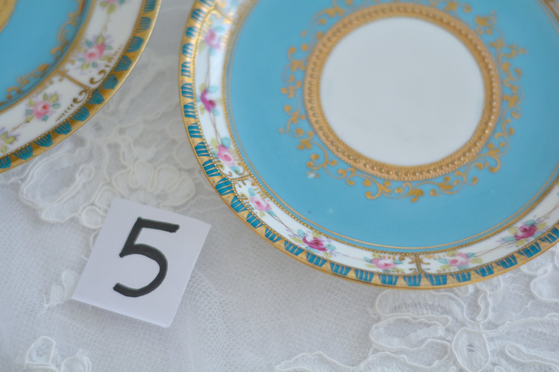 L&COという日本のメーカーのアンティーク里帰り品です。美しいターコイズブルーに金盛りの金彩、ハンドペイントで描かれた可憐なバラが上品なお品。1800年代後半頃からノリタケをはじめ日本からたくさんのメーカーが英国やアメリカに陶磁器を輸出していました。L&COは英国の老舗デパートリバティで販売されていたと言われています。キラキラしたティーセットがデパートに並べられている風景は、当時の人々の目と心を楽しませていたことでしょう。オールドニッポンの美しいティーカップでティータイムをお楽しみください。