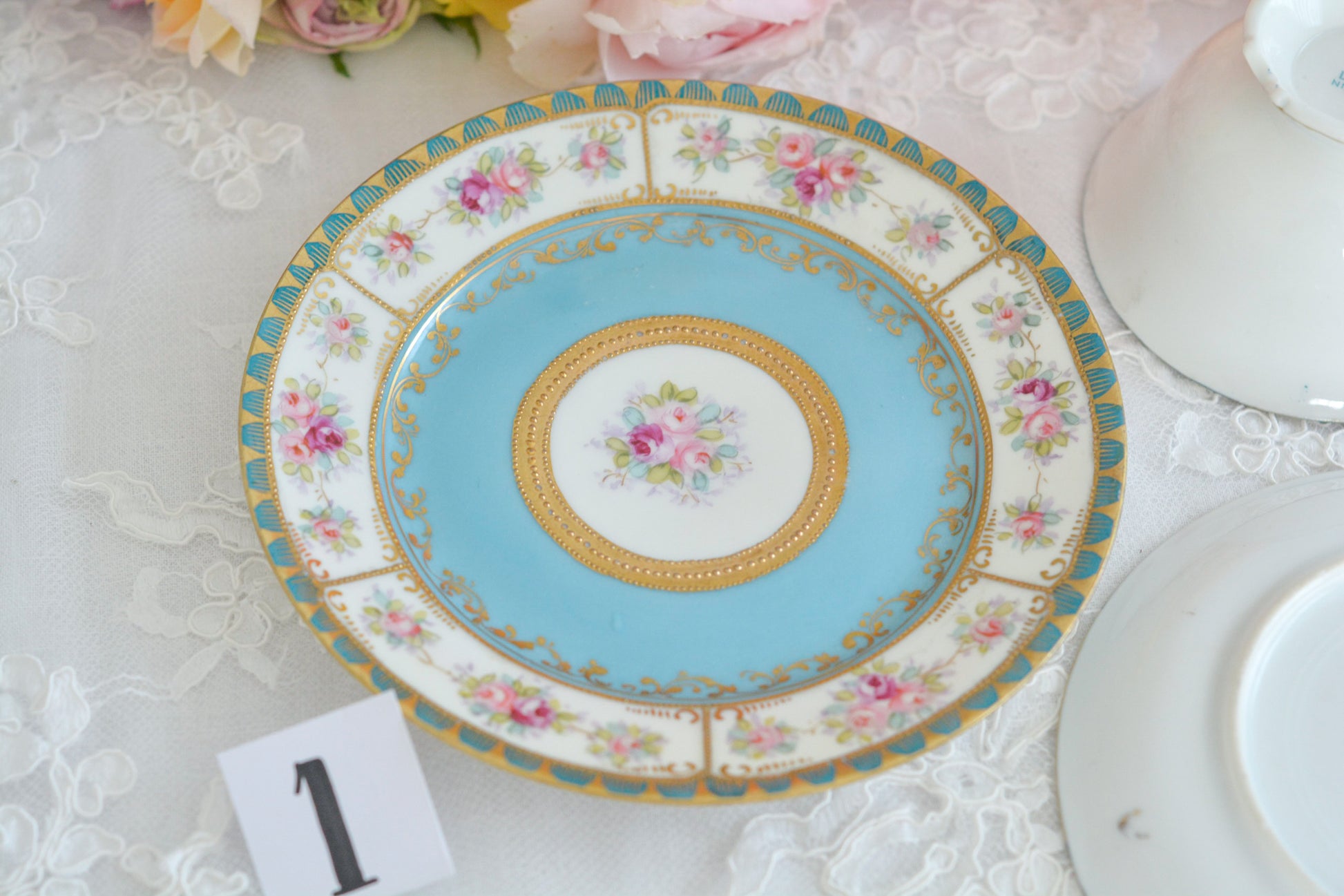 L&COという日本のメーカーのアンティーク里帰り品です。美しいターコイズブルーに金盛りの金彩、ハンドペイントで描かれた可憐なバラが上品なお品。1800年代後半頃からノリタケをはじめ日本からたくさんのメーカーが英国やアメリカに陶磁器を輸出していました。L&COは英国の老舗デパートリバティで販売されていたと言われています。キラキラしたティーセットがデパートに並べられている風景は、当時の人々の目と心を楽しませていたことでしょう。オールドニッポンの美しいティーカップでティータイムをお楽しみください。