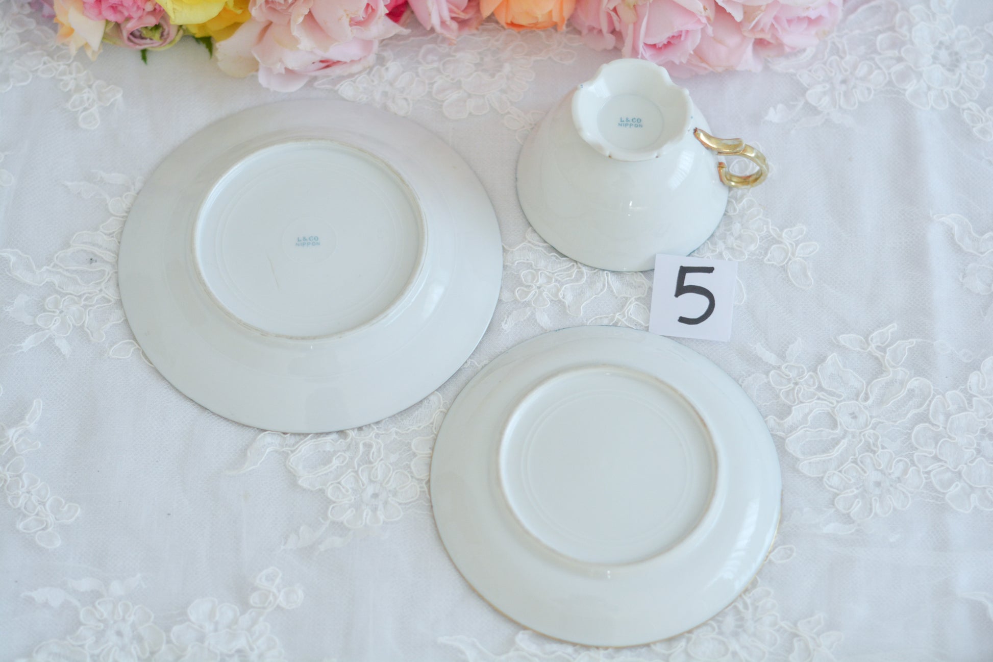 L&COという日本のメーカーのアンティーク里帰り品です。美しいターコイズブルーに金盛りの金彩、ハンドペイントで描かれた可憐なバラが上品なお品。1800年代後半頃からノリタケをはじめ日本からたくさんのメーカーが英国やアメリカに陶磁器を輸出していました。L&COは英国の老舗デパートリバティで販売されていたと言われています。キラキラしたティーセットがデパートに並べられている風景は、当時の人々の目と心を楽しませていたことでしょう。オールドニッポンの美しいティーカップでティータイムをお楽しみください。