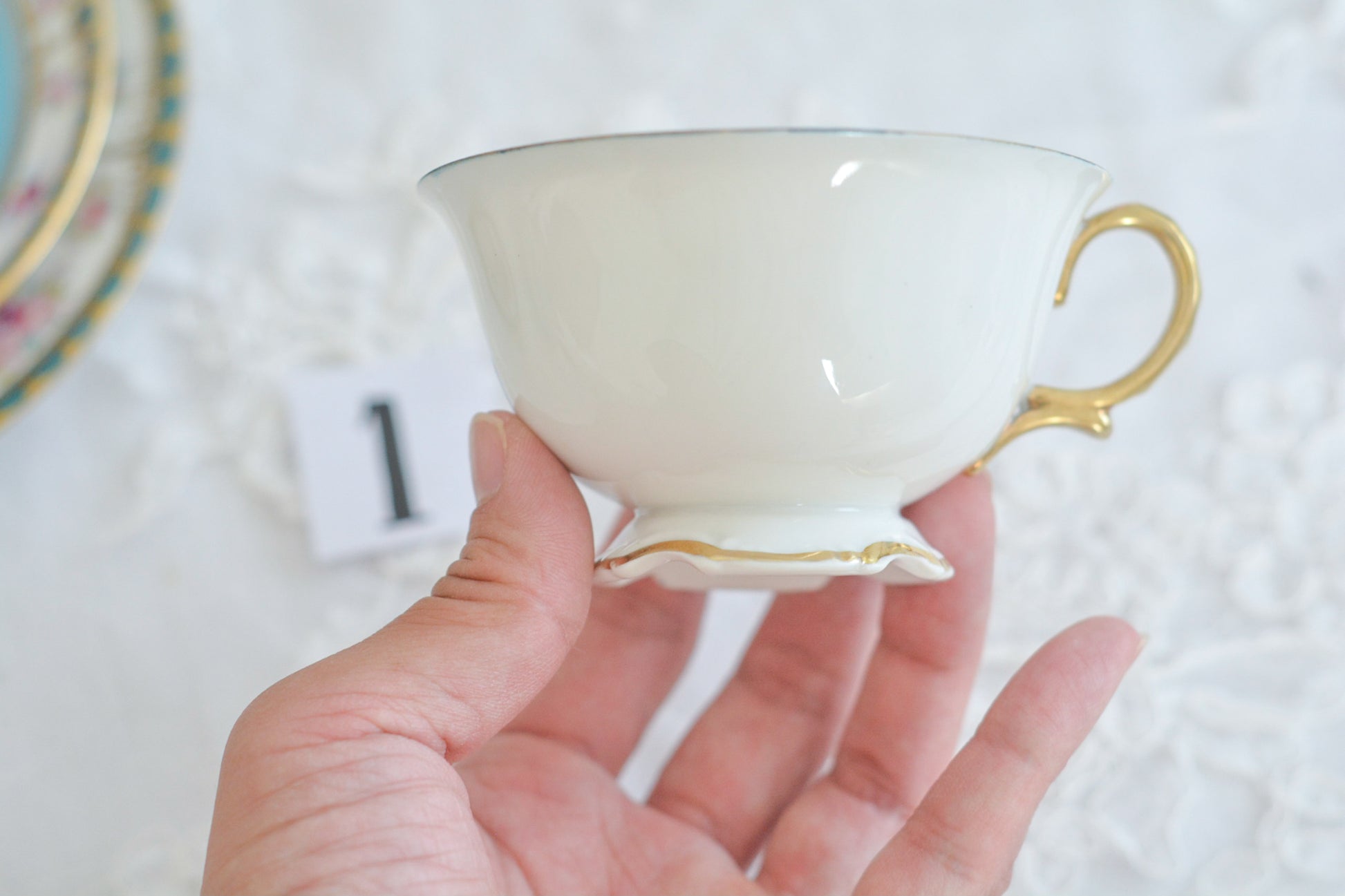 L&COという日本のメーカーのアンティーク里帰り品です。美しいターコイズブルーに金盛りの金彩、ハンドペイントで描かれた可憐なバラが上品なお品。1800年代後半頃からノリタケをはじめ日本からたくさんのメーカーが英国やアメリカに陶磁器を輸出していました。L&COは英国の老舗デパートリバティで販売されていたと言われています。キラキラしたティーセットがデパートに並べられている風景は、当時の人々の目と心を楽しませていたことでしょう。オールドニッポンの美しいティーカップでティータイムをお楽しみください。