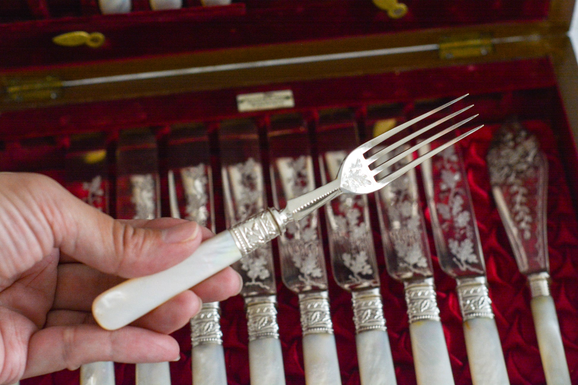 オークの木箱に入った白蝶貝ハンドルのカトラリーセット。元はフォーク&ナイフ12組のセットだったと思いますが今は8組のセットになっていて、同じシリーズではありませんが、サービングスプーンとサービングナイフがセットに加えられています。繊細な彫刻と白蝶貝の優しい輝きがとても美しいセットです。白蝶貝もたっぷりと使われていて贅沢なお品です。