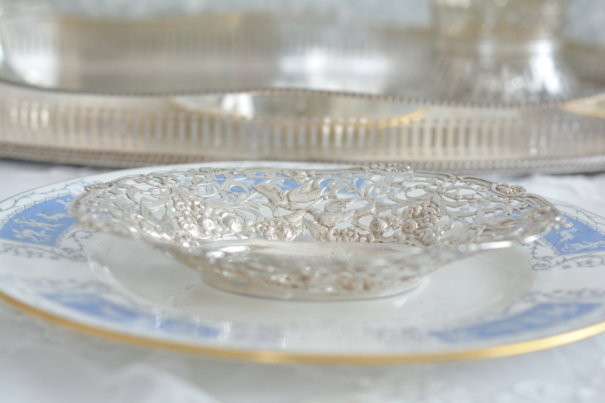 天使にリボンと薔薇のガーランドのピアス細工がとても愛らしく美しいボンボンディッシュです。 こちらはドイツで作られてイギリスに輸入されたお品です。繊細なピアス細工(透かし模様)に可愛らしい天使達がとても美しいお品です。ボンボンディッシュとはチョコレートやキャンディーなど小さなお菓子を入れて、ゲストがつまめるようにテーブルなどに置いておくためのお皿で、テーブルやお部屋に置かれていました。小ぶりなお皿で、ちょっとしたお菓子を乗せるのにぴったりです。