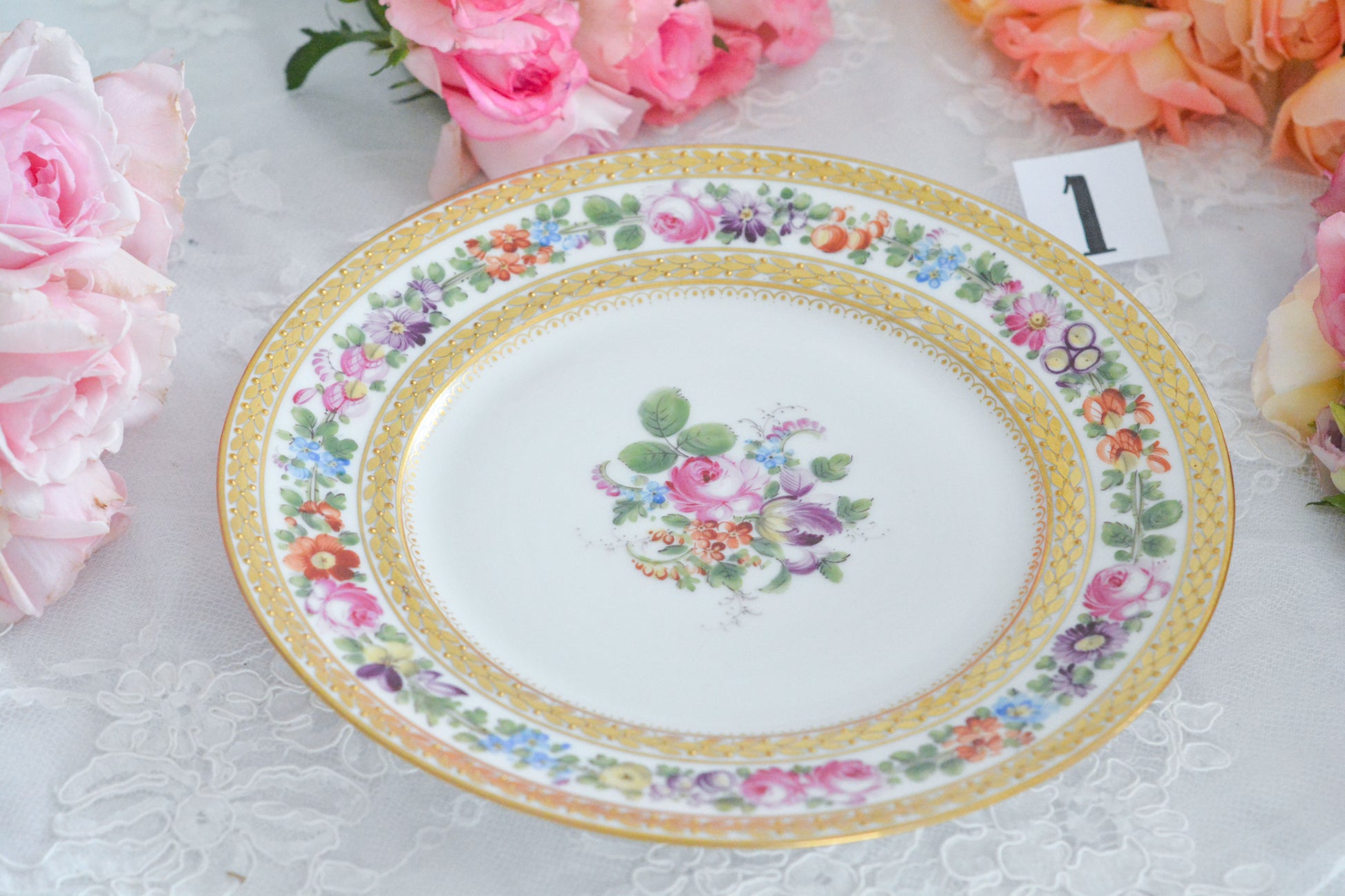 こちらのプレート達はドレスデンの工房で作られてはいますが、カール・ティーメ工房の作品ではありません。特に美しいので特集コーナーに入れさせていただきました。ハンドペイントで描かれた美しい花々に金彩の葉っぱの模様のような縁取りが豪華なお品。金盛りのドットがより花を添えています。キャビネットプレートとしても実際にお使いいただいても素敵なお品です。バックスタンプは1883年〜1893年頃に使われていた王冠マークで、いくつかの工房が集まって使用していました。バックスタンの上には金彩でお花が描かれています。