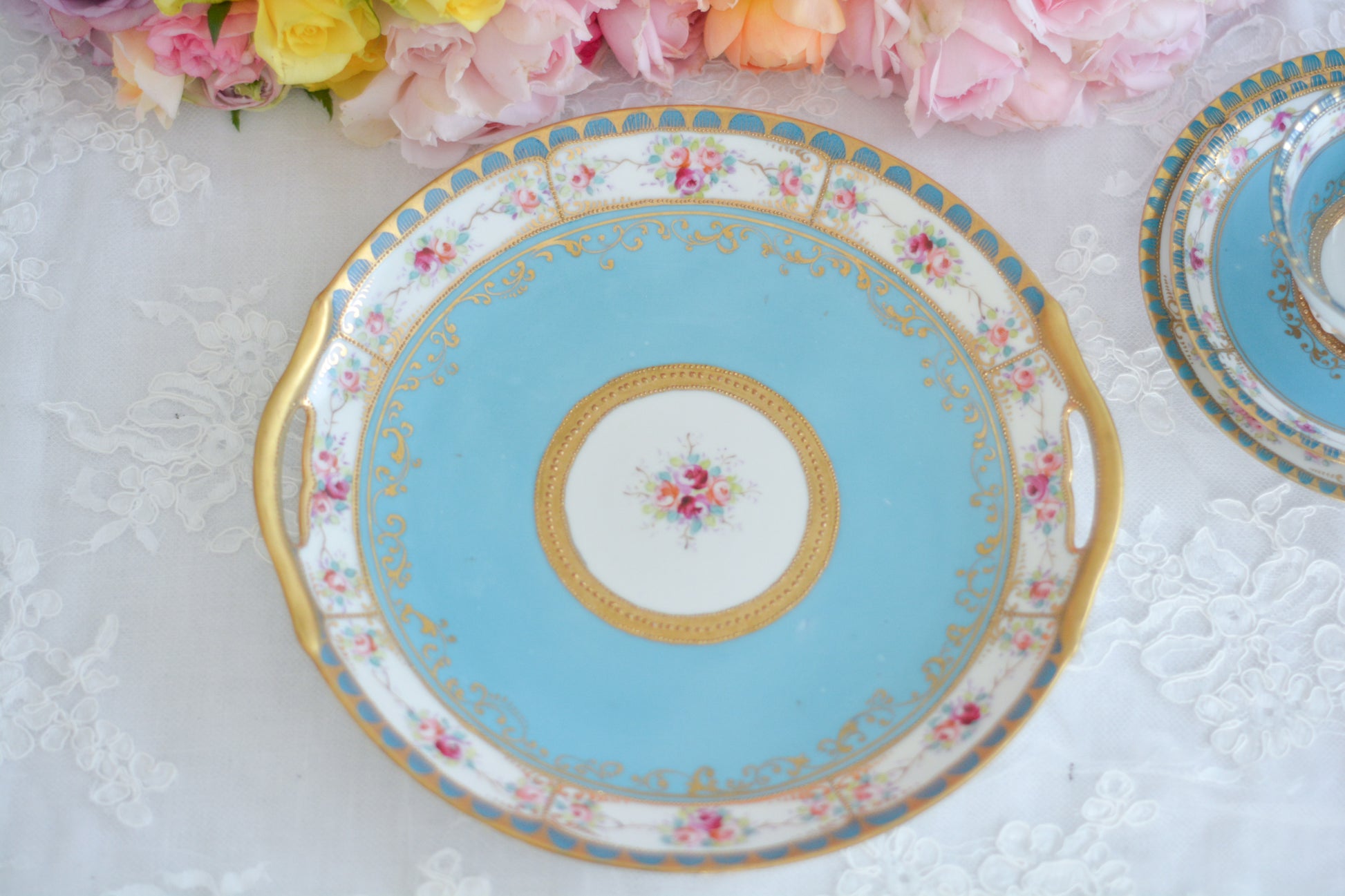 L&COという日本のメーカーのアンティーク里帰り品です。美しいターコイズブルーに金盛りの金彩、ハンドペイントで描かれた可憐なバラが上品なお品。1800年代後半頃からノリタケをはじめ日本からたくさんのメーカーが英国やアメリカに陶磁器を輸出していました。L&COは英国の老舗デパートリバティで販売されていたと言われています。キラキラしたティーセットやプレート達がデパートに並べられている風景は、当時の人々の目と心を楽しませていたことでしょう。