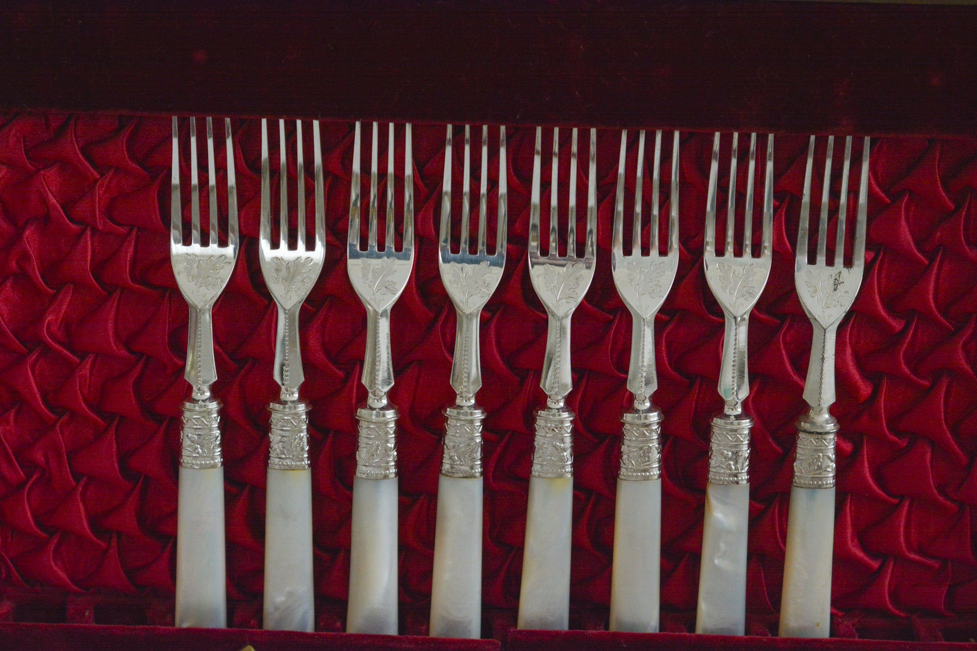 オークの木箱に入った白蝶貝ハンドルのカトラリーセット。元はフォーク&ナイフ12組のセットだったと思いますが今は8組のセットになっていて、同じシリーズではありませんが、サービングスプーンとサービングナイフがセットに加えられています。繊細な彫刻と白蝶貝の優しい輝きがとても美しいセットです。白蝶貝もたっぷりと使われていて贅沢なお品です。