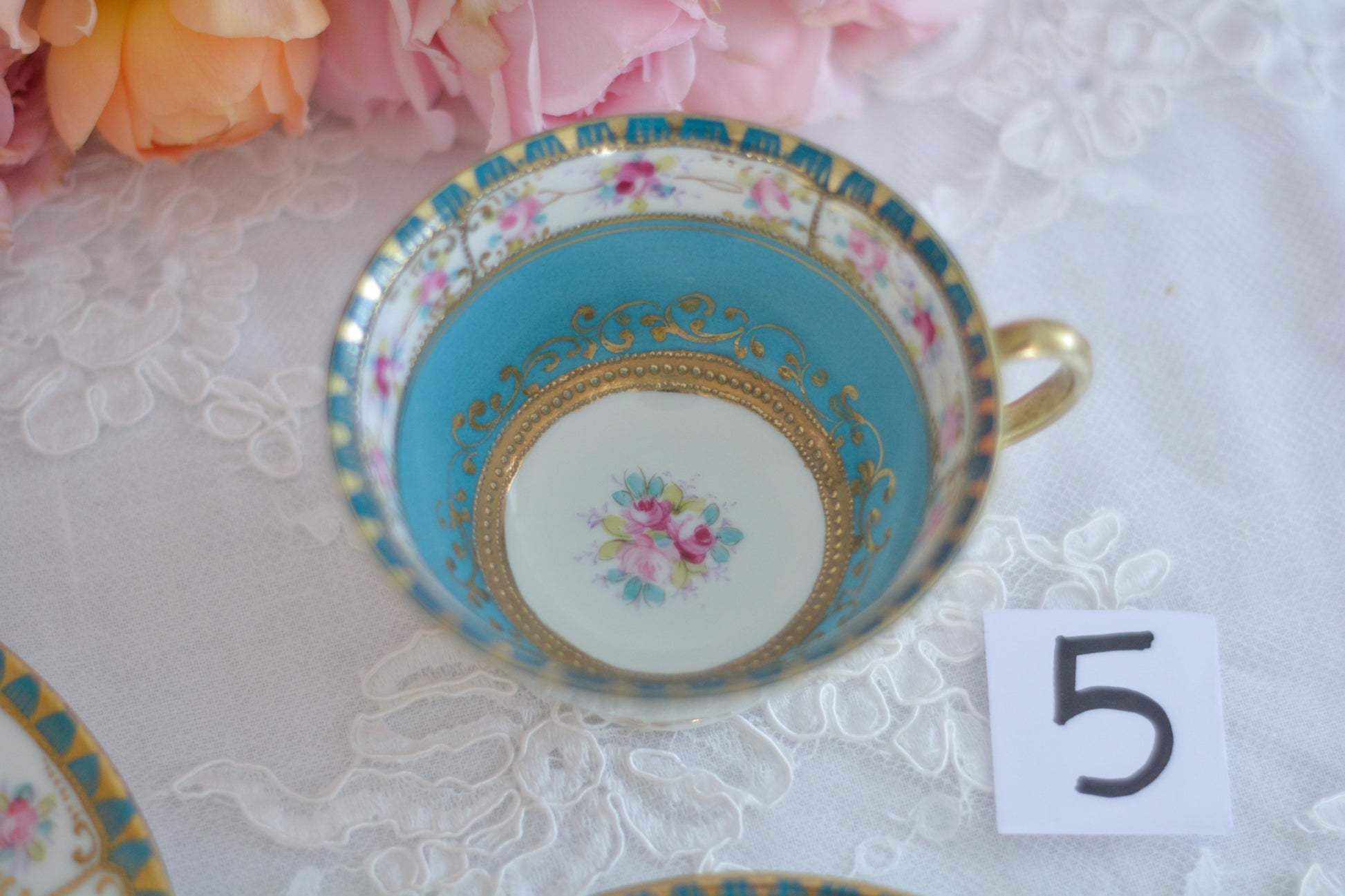 L&COという日本のメーカーのアンティーク里帰り品です。美しいターコイズブルーに金盛りの金彩、ハンドペイントで描かれた可憐なバラが上品なお品。1800年代後半頃からノリタケをはじめ日本からたくさんのメーカーが英国やアメリカに陶磁器を輸出していました。L&COは英国の老舗デパートリバティで販売されていたと言われています。キラキラしたティーセットがデパートに並べられている風景は、当時の人々の目と心を楽しませていたことでしょう。オールドニッポンの美しいティーカップでティータイムをお楽しみください。