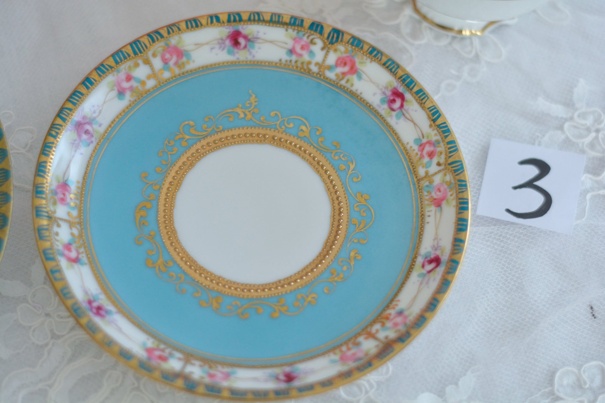 L&COという日本のメーカーのアンティーク里帰り品です。美しいターコイズブルーに金盛りの金彩、ハンドペイントで描かれた可憐なバラが上品なお品。1800年代後半頃からノリタケをはじめ日本からたくさんのメーカーが英国やアメリカに陶磁器を輸出していました。L&COは英国の老舗デパートリバティで販売されていたと言われています。キラキラしたティーセットがデパートに並べられている風景は、当時の人々の目と心を楽しませていたことでしょう。オールドニッポンの美しいティーカップでティータイムをお楽しみください。