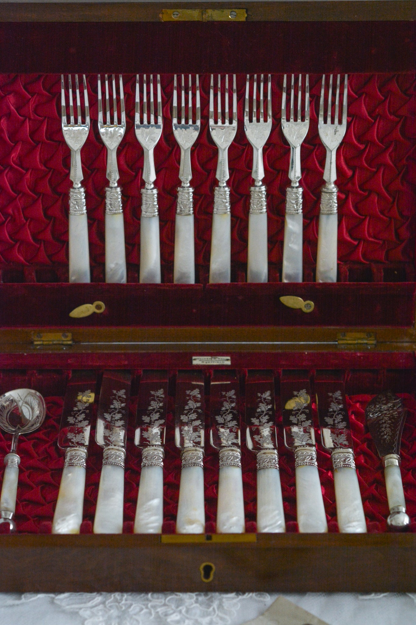 オークの木箱に入った白蝶貝ハンドルのカトラリーセット。元はフォーク&ナイフ12組のセットだったと思いますが今は8組のセットになっていて、同じシリーズではありませんが、サービングスプーンとサービングナイフがセットに加えられています。繊細な彫刻と白蝶貝の優しい輝きがとても美しいセットです。白蝶貝もたっぷりと使われていて贅沢なお品です。