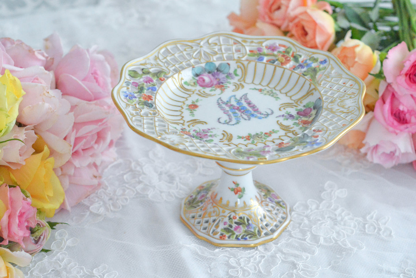 カール・ティーメ工房の花文字でマリーアントワネットの頭文字MとAが描かれた美しいコンポートです。透かし模様のお花や金彩もハンドペイントで丁寧に描かれています。豪華な雰囲気がマリーアントワネットの世界観にぴったりなお品です。ちょっと小ぶりなコンポートで、小さな焼き菓子やチョコレートなどを盛り付けても素敵ですね。マリーアントワネットのプレートも貴重ですが、コンポートはさらに見つけるのが困難なお品です。