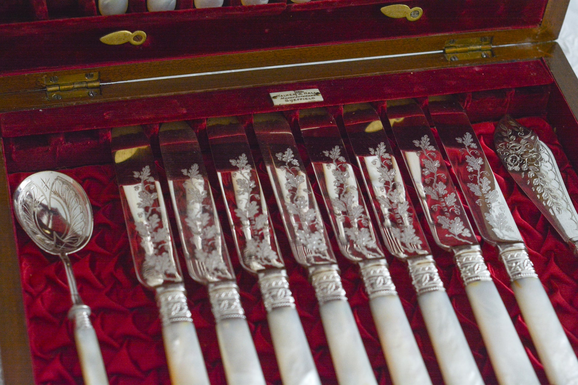 オークの木箱に入った白蝶貝ハンドルのカトラリーセット。元はフォーク&ナイフ12組のセットだったと思いますが今は8組のセットになっていて、同じシリーズではありませんが、サービングスプーンとサービングナイフがセットに加えられています。繊細な彫刻と白蝶貝の優しい輝きがとても美しいセットです。白蝶貝もたっぷりと使われていて贅沢なお品です。