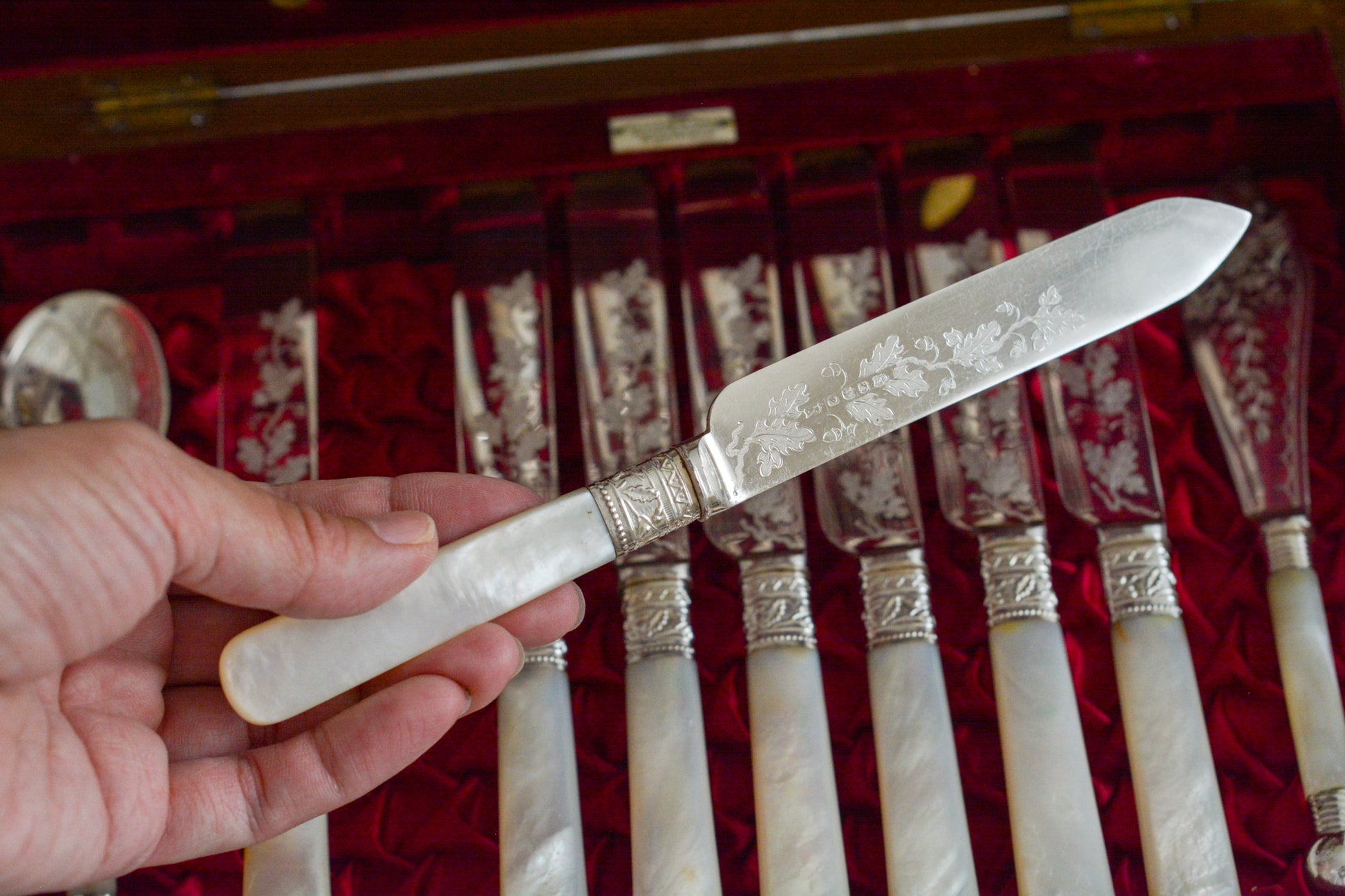 オークの木箱に入った白蝶貝ハンドルのカトラリーセット。元はフォーク&ナイフ12組のセットだったと思いますが今は8組のセットになっていて、同じシリーズではありませんが、サービングスプーンとサービングナイフがセットに加えられています。繊細な彫刻と白蝶貝の優しい輝きがとても美しいセットです。白蝶貝もたっぷりと使われていて贅沢なお品です。