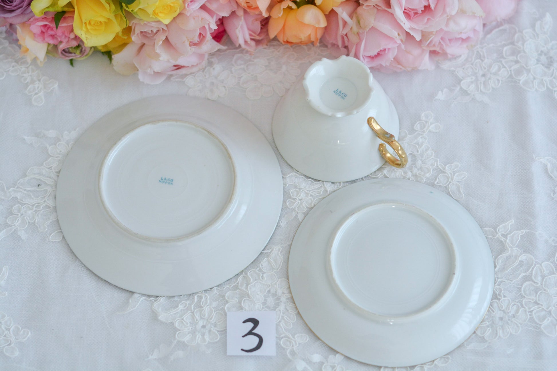 L&COという日本のメーカーのアンティーク里帰り品です。美しいターコイズブルーに金盛りの金彩、ハンドペイントで描かれた可憐なバラが上品なお品。1800年代後半頃からノリタケをはじめ日本からたくさんのメーカーが英国やアメリカに陶磁器を輸出していました。L&COは英国の老舗デパートリバティで販売されていたと言われています。キラキラしたティーセットがデパートに並べられている風景は、当時の人々の目と心を楽しませていたことでしょう。オールドニッポンの美しいティーカップでティータイムをお楽しみください。