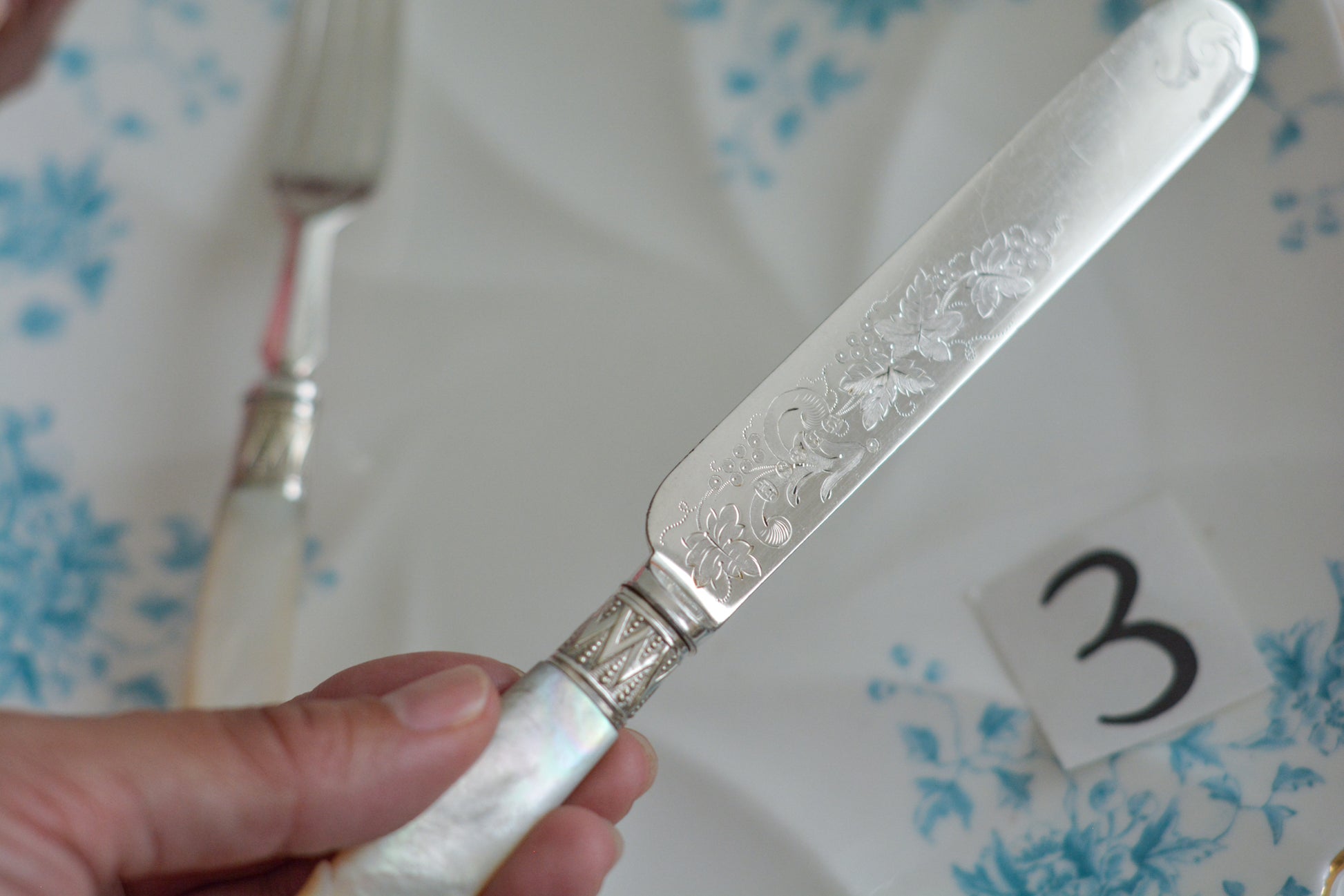 白蝶貝ハンドルと人気の丸刃のカトラリー。こちらは白蝶貝にも手彫りで模様が彫られています。シルバープレートのブレードに少しスレが見られます(状態を考慮した価格になっております)が、白蝶貝の優しい輝きと繊細な模様がとても美しいお品です。こちらは1組(フォークとナイフ2本セット)からご購入いただけます。①〜③からお選びください。