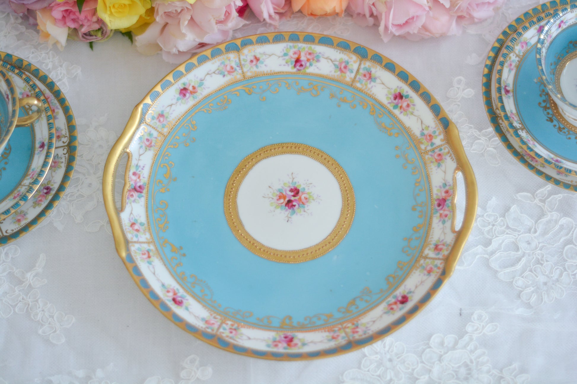 L&COという日本のメーカーのアンティーク里帰り品です。美しいターコイズブルーに金盛りの金彩、ハンドペイントで描かれた可憐なバラが上品なお品。1800年代後半頃からノリタケをはじめ日本からたくさんのメーカーが英国やアメリカに陶磁器を輸出していました。L&COは英国の老舗デパートリバティで販売されていたと言われています。キラキラしたティーセットやプレート達がデパートに並べられている風景は、当時の人々の目と心を楽しませていたことでしょう。