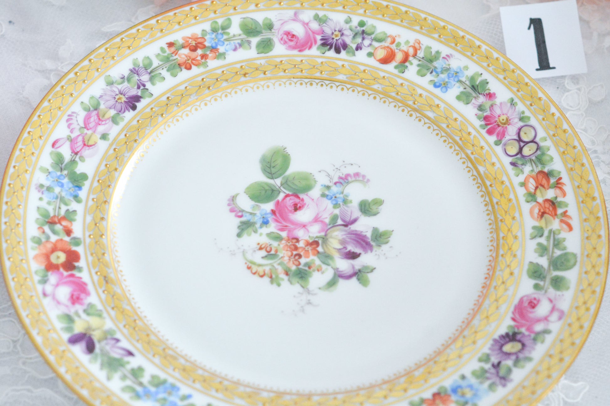 こちらのプレート達はドレスデンの工房で作られてはいますが、カール・ティーメ工房の作品ではありません。特に美しいので特集コーナーに入れさせていただきました。ハンドペイントで描かれた美しい花々に金彩の葉っぱの模様のような縁取りが豪華なお品。金盛りのドットがより花を添えています。キャビネットプレートとしても実際にお使いいただいても素敵なお品です。バックスタンプは1883年〜1893年頃に使われていた王冠マークで、いくつかの工房が集まって使用していました。バックスタンの上には金彩でお花が描かれています。