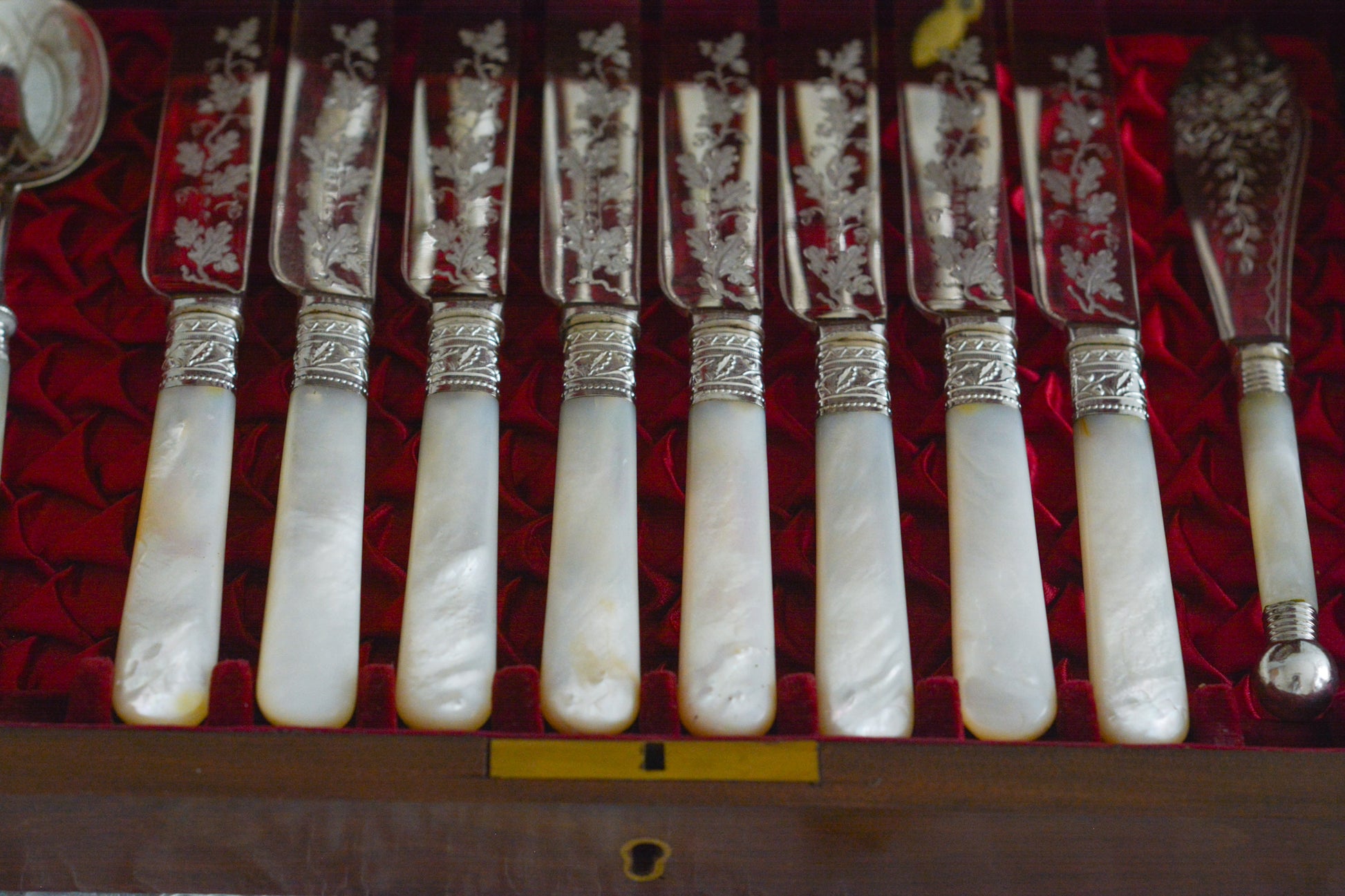 オークの木箱に入った白蝶貝ハンドルのカトラリーセット。元はフォーク&ナイフ12組のセットだったと思いますが今は8組のセットになっていて、同じシリーズではありませんが、サービングスプーンとサービングナイフがセットに加えられています。繊細な彫刻と白蝶貝の優しい輝きがとても美しいセットです。白蝶貝もたっぷりと使われていて贅沢なお品です。