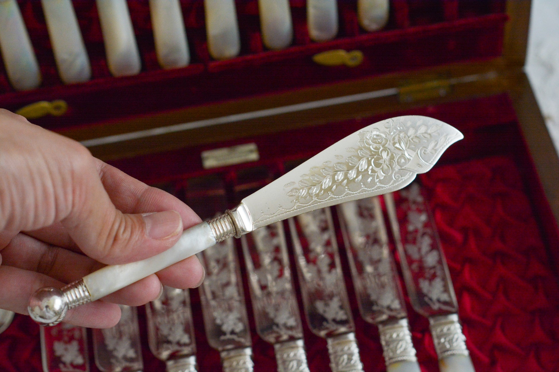 オークの木箱に入った白蝶貝ハンドルのカトラリーセット。元はフォーク&ナイフ12組のセットだったと思いますが今は8組のセットになっていて、同じシリーズではありませんが、サービングスプーンとサービングナイフがセットに加えられています。繊細な彫刻と白蝶貝の優しい輝きがとても美しいセットです。白蝶貝もたっぷりと使われていて贅沢なお品です。