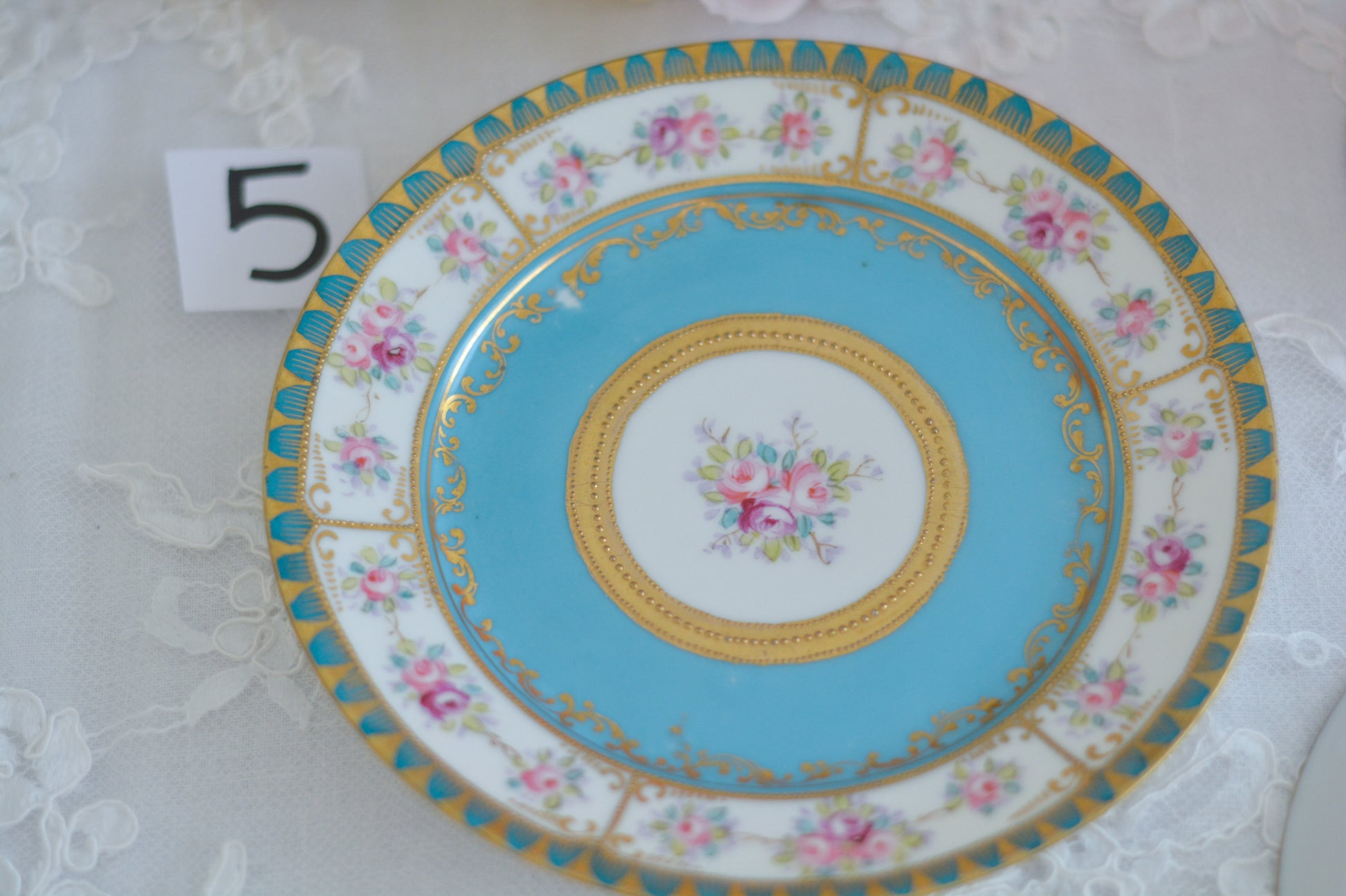 L&COという日本のメーカーのアンティーク里帰り品です。美しいターコイズブルーに金盛りの金彩、ハンドペイントで描かれた可憐なバラが上品なお品。1800年代後半頃からノリタケをはじめ日本からたくさんのメーカーが英国やアメリカに陶磁器を輸出していました。L&COは英国の老舗デパートリバティで販売されていたと言われています。キラキラしたティーセットがデパートに並べられている風景は、当時の人々の目と心を楽しませていたことでしょう。オールドニッポンの美しいティーカップでティータイムをお楽しみください。