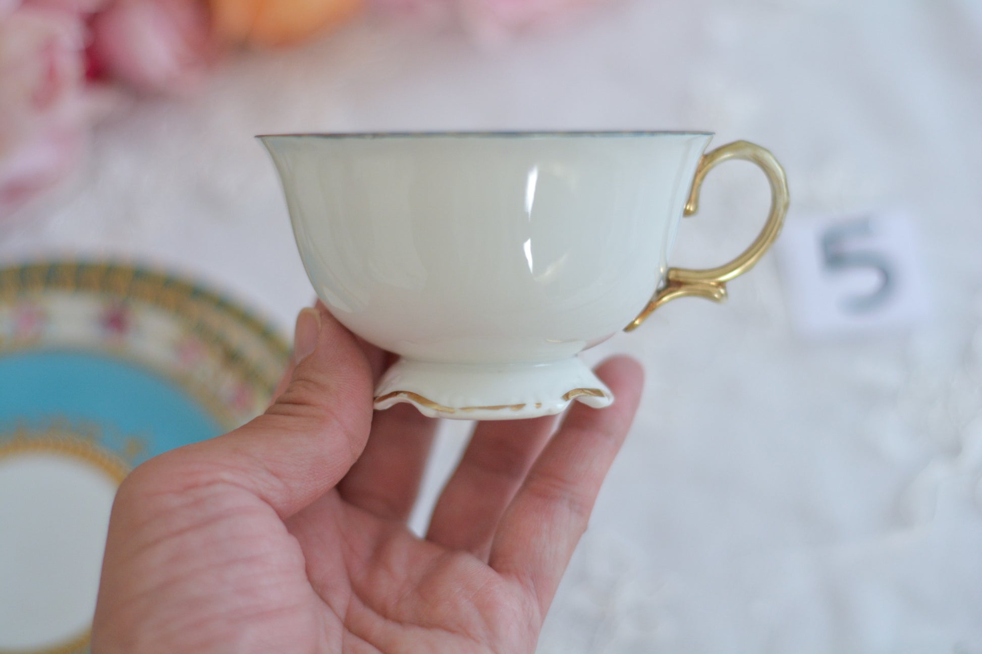 L&COという日本のメーカーのアンティーク里帰り品です。美しいターコイズブルーに金盛りの金彩、ハンドペイントで描かれた可憐なバラが上品なお品。1800年代後半頃からノリタケをはじめ日本からたくさんのメーカーが英国やアメリカに陶磁器を輸出していました。L&COは英国の老舗デパートリバティで販売されていたと言われています。キラキラしたティーセットがデパートに並べられている風景は、当時の人々の目と心を楽しませていたことでしょう。オールドニッポンの美しいティーカップでティータイムをお楽しみください。