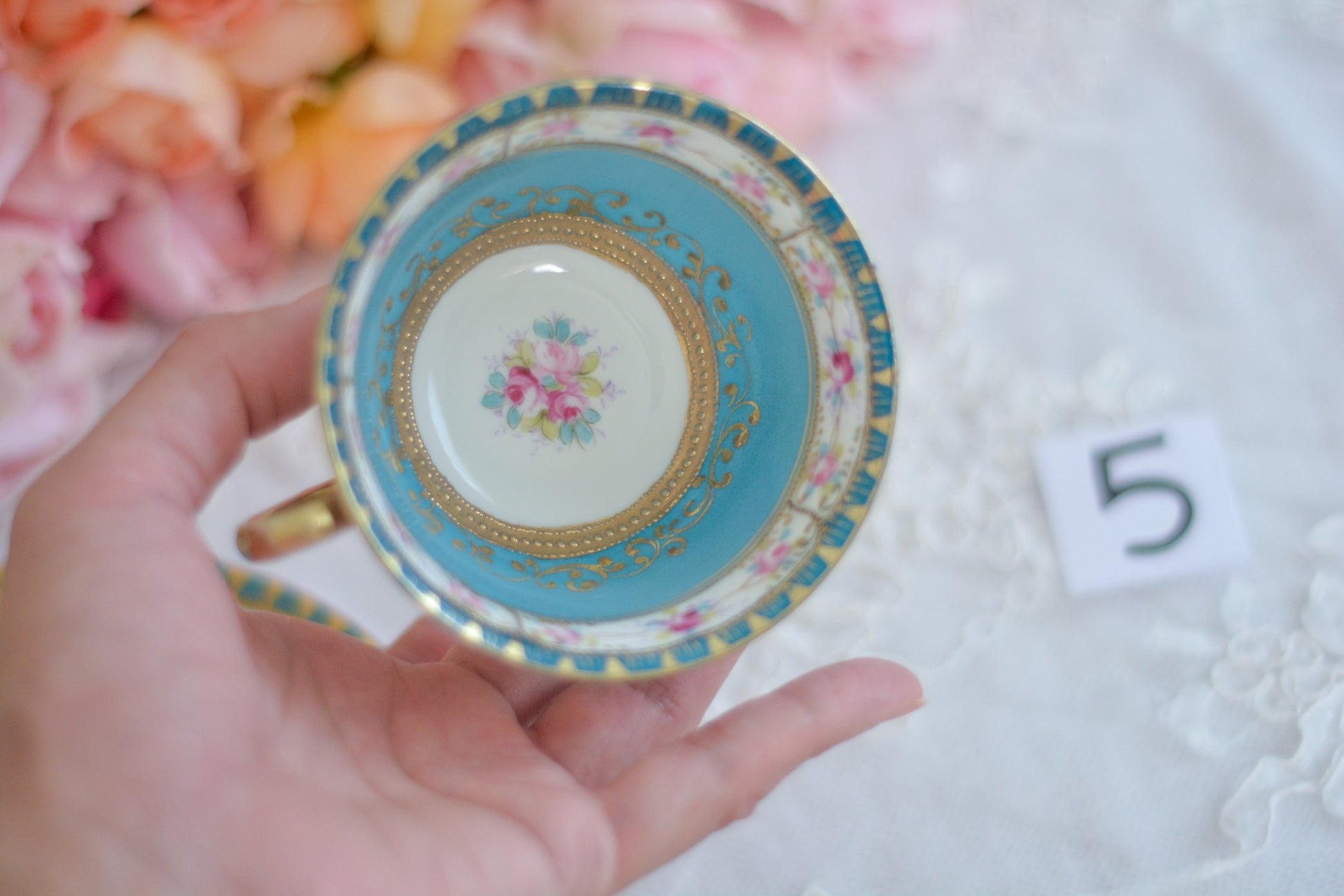 L&COという日本のメーカーのアンティーク里帰り品です。美しいターコイズブルーに金盛りの金彩、ハンドペイントで描かれた可憐なバラが上品なお品。1800年代後半頃からノリタケをはじめ日本からたくさんのメーカーが英国やアメリカに陶磁器を輸出していました。L&COは英国の老舗デパートリバティで販売されていたと言われています。キラキラしたティーセットがデパートに並べられている風景は、当時の人々の目と心を楽しませていたことでしょう。オールドニッポンの美しいティーカップでティータイムをお楽しみください。