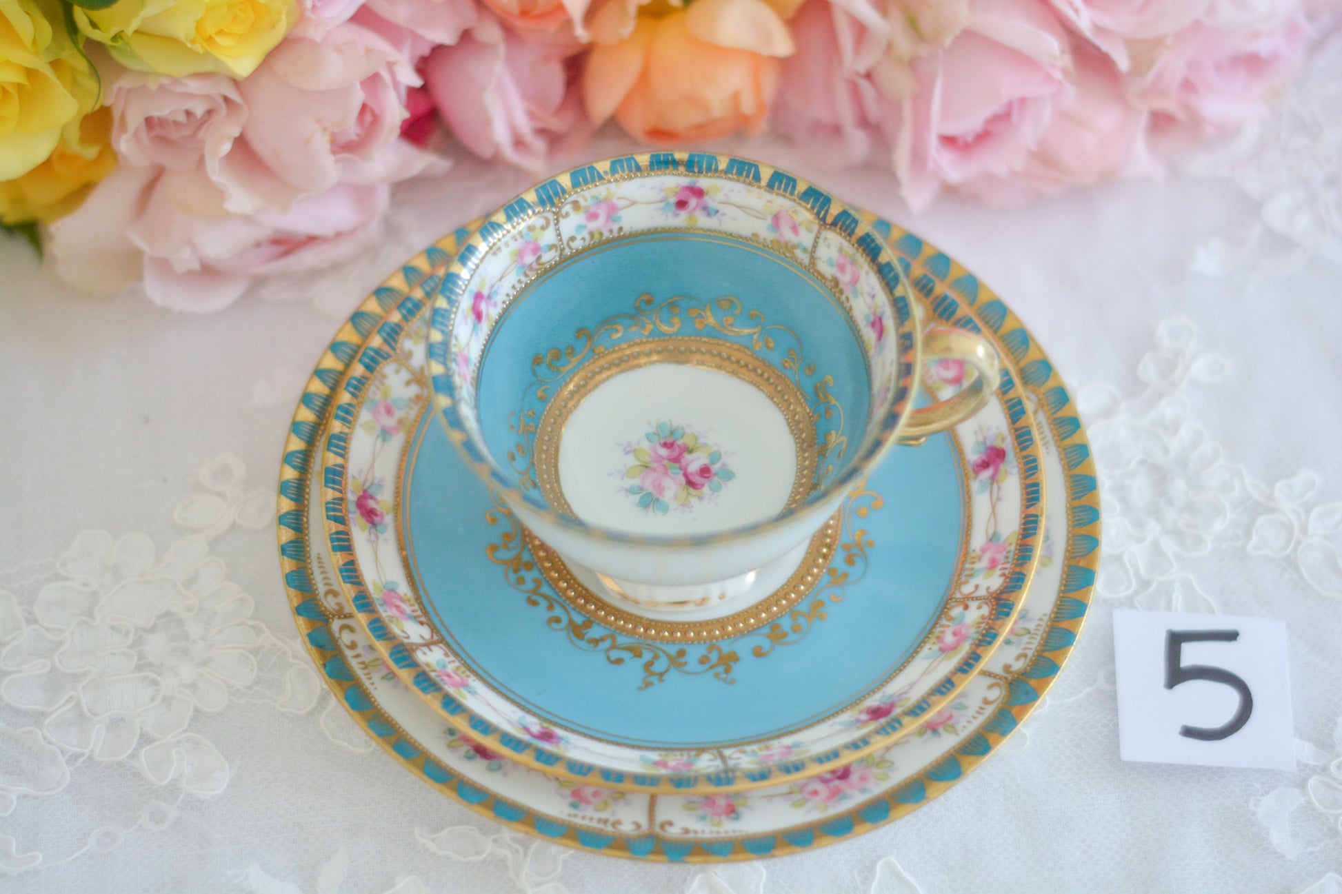 L&COという日本のメーカーのアンティーク里帰り品です。美しいターコイズブルーに金盛りの金彩、ハンドペイントで描かれた可憐なバラが上品なお品。1800年代後半頃からノリタケをはじめ日本からたくさんのメーカーが英国やアメリカに陶磁器を輸出していました。L&COは英国の老舗デパートリバティで販売されていたと言われています。キラキラしたティーセットがデパートに並べられている風景は、当時の人々の目と心を楽しませていたことでしょう。オールドニッポンの美しいティーカップでティータイムをお楽しみください。