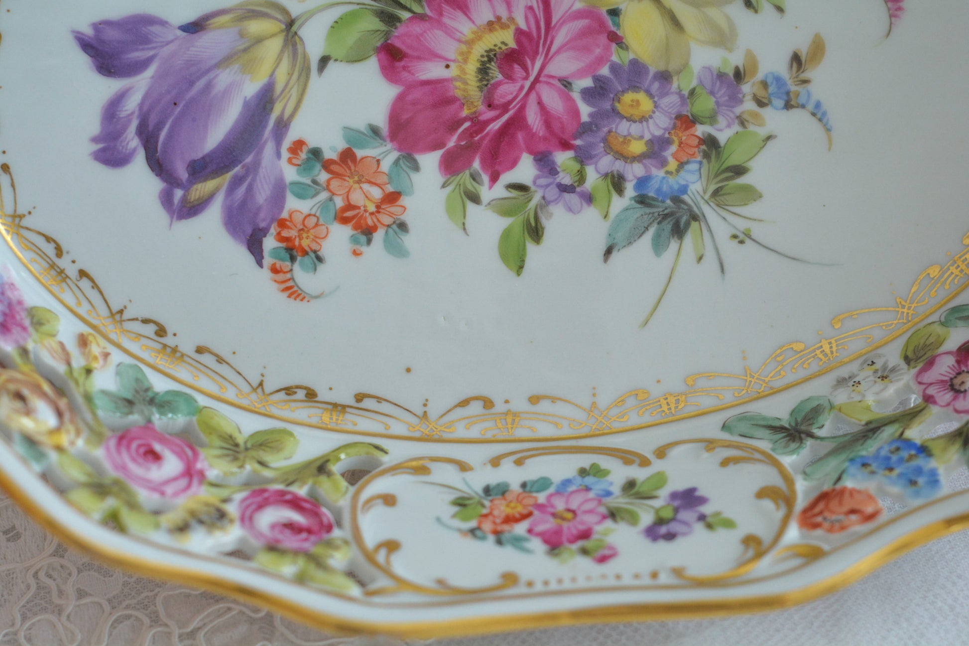 ドイツドレスデン、カール・ティーメ工房のバスケット。透かし模様にハンドペイントで花々が絵付けされていて大変豪華なお品です。持ち手もロープハンドルで凝った作りなのがさすがカール・ティーメ。ドレスデンの磁器は通常、素磁は仕入れて絵付のみを行っていますが、カール・ティーメ工房だけは素磁も自社で製造しています。ハンドペイントの技術も素晴らしく、とにかく美しい。こちらのバスケットも上から見ても横から見ても華やかで美しいバスケットとなっております。