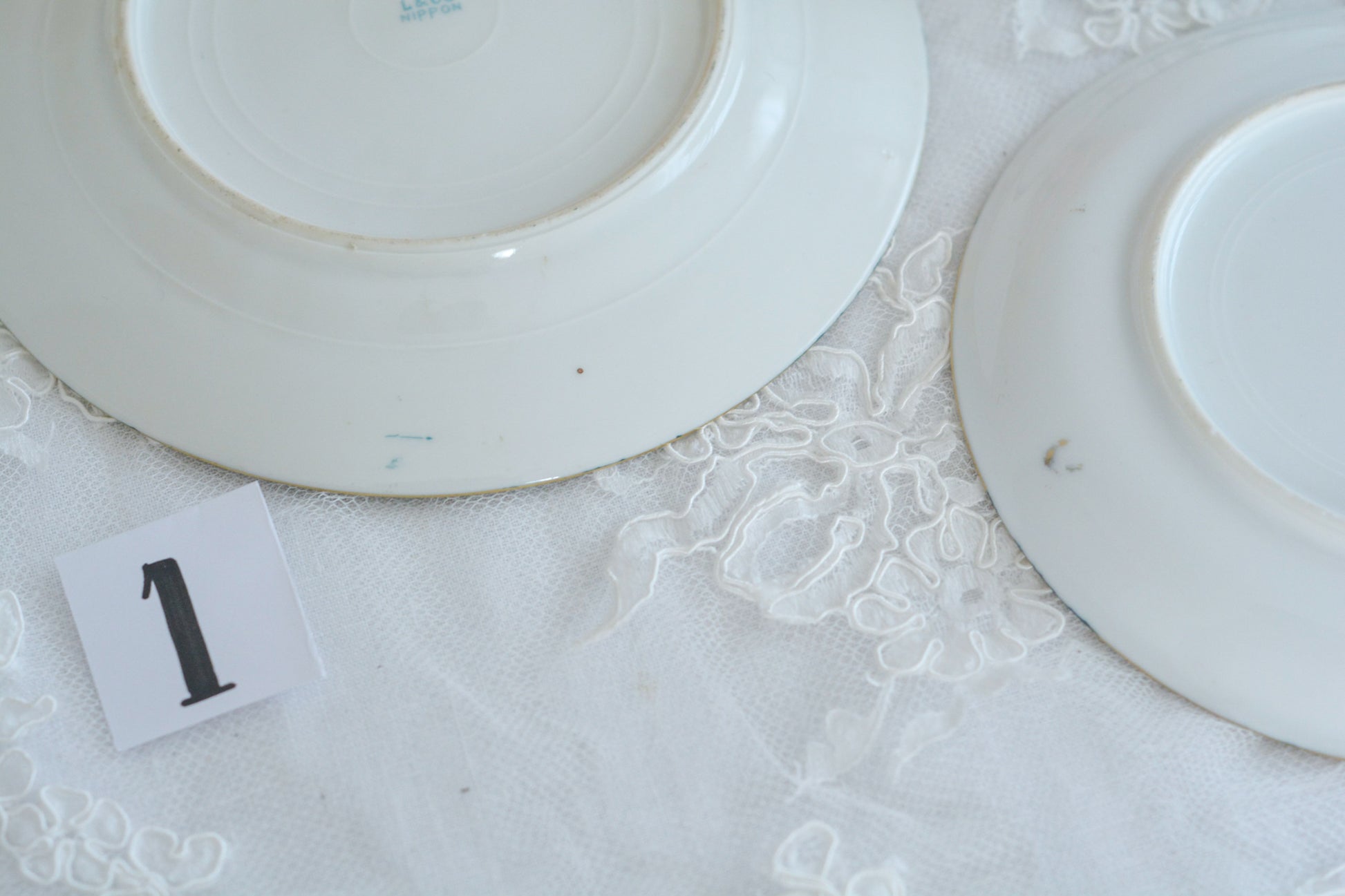 L&COという日本のメーカーのアンティーク里帰り品です。美しいターコイズブルーに金盛りの金彩、ハンドペイントで描かれた可憐なバラが上品なお品。1800年代後半頃からノリタケをはじめ日本からたくさんのメーカーが英国やアメリカに陶磁器を輸出していました。L&COは英国の老舗デパートリバティで販売されていたと言われています。キラキラしたティーセットがデパートに並べられている風景は、当時の人々の目と心を楽しませていたことでしょう。オールドニッポンの美しいティーカップでティータイムをお楽しみください。