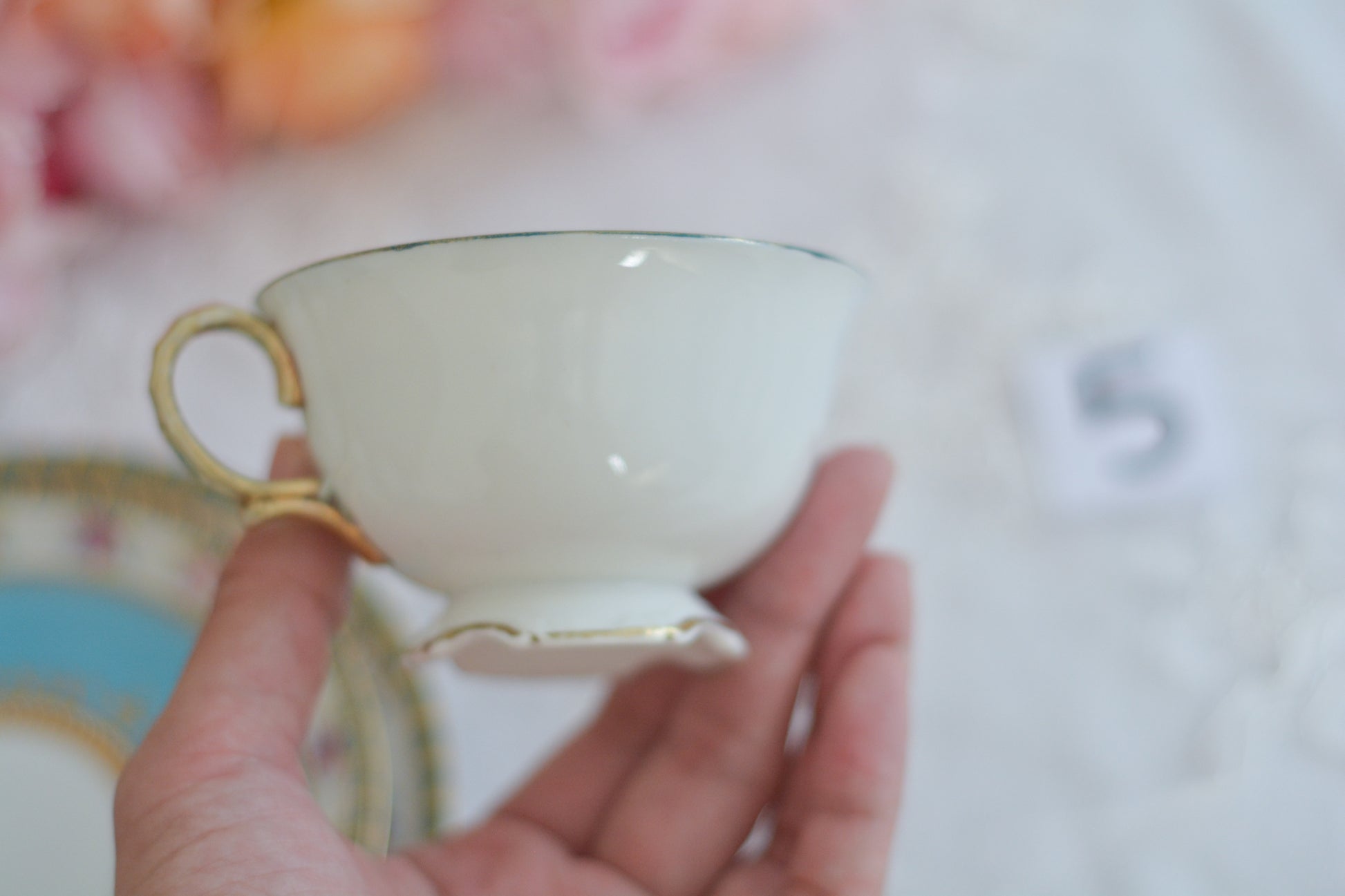 L&COという日本のメーカーのアンティーク里帰り品です。美しいターコイズブルーに金盛りの金彩、ハンドペイントで描かれた可憐なバラが上品なお品。1800年代後半頃からノリタケをはじめ日本からたくさんのメーカーが英国やアメリカに陶磁器を輸出していました。L&COは英国の老舗デパートリバティで販売されていたと言われています。キラキラしたティーセットがデパートに並べられている風景は、当時の人々の目と心を楽しませていたことでしょう。オールドニッポンの美しいティーカップでティータイムをお楽しみください。