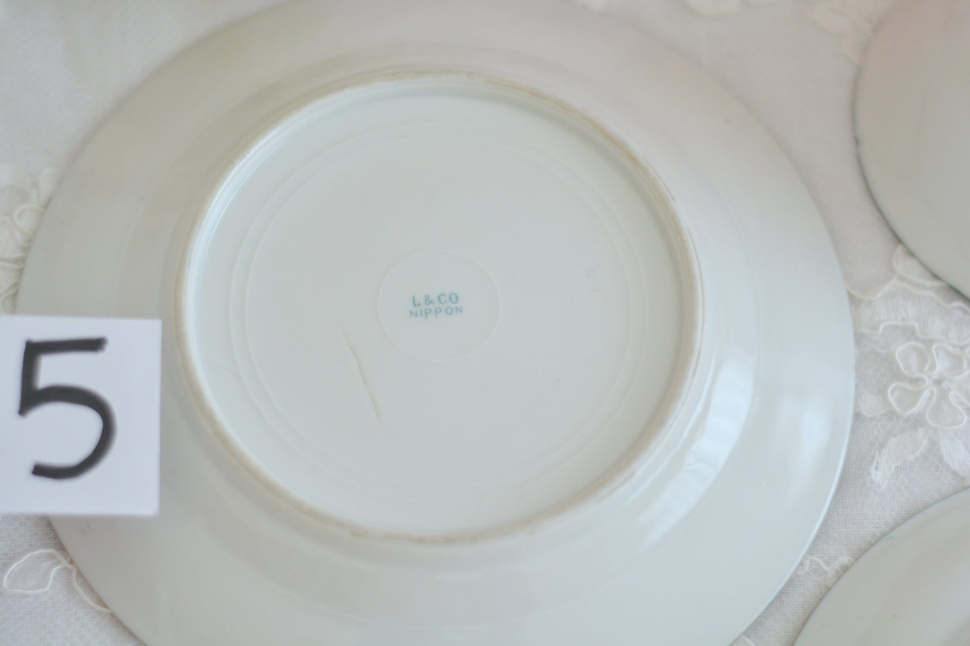 L&COという日本のメーカーのアンティーク里帰り品です。美しいターコイズブルーに金盛りの金彩、ハンドペイントで描かれた可憐なバラが上品なお品。1800年代後半頃からノリタケをはじめ日本からたくさんのメーカーが英国やアメリカに陶磁器を輸出していました。L&COは英国の老舗デパートリバティで販売されていたと言われています。キラキラしたティーセットがデパートに並べられている風景は、当時の人々の目と心を楽しませていたことでしょう。オールドニッポンの美しいティーカップでティータイムをお楽しみください。