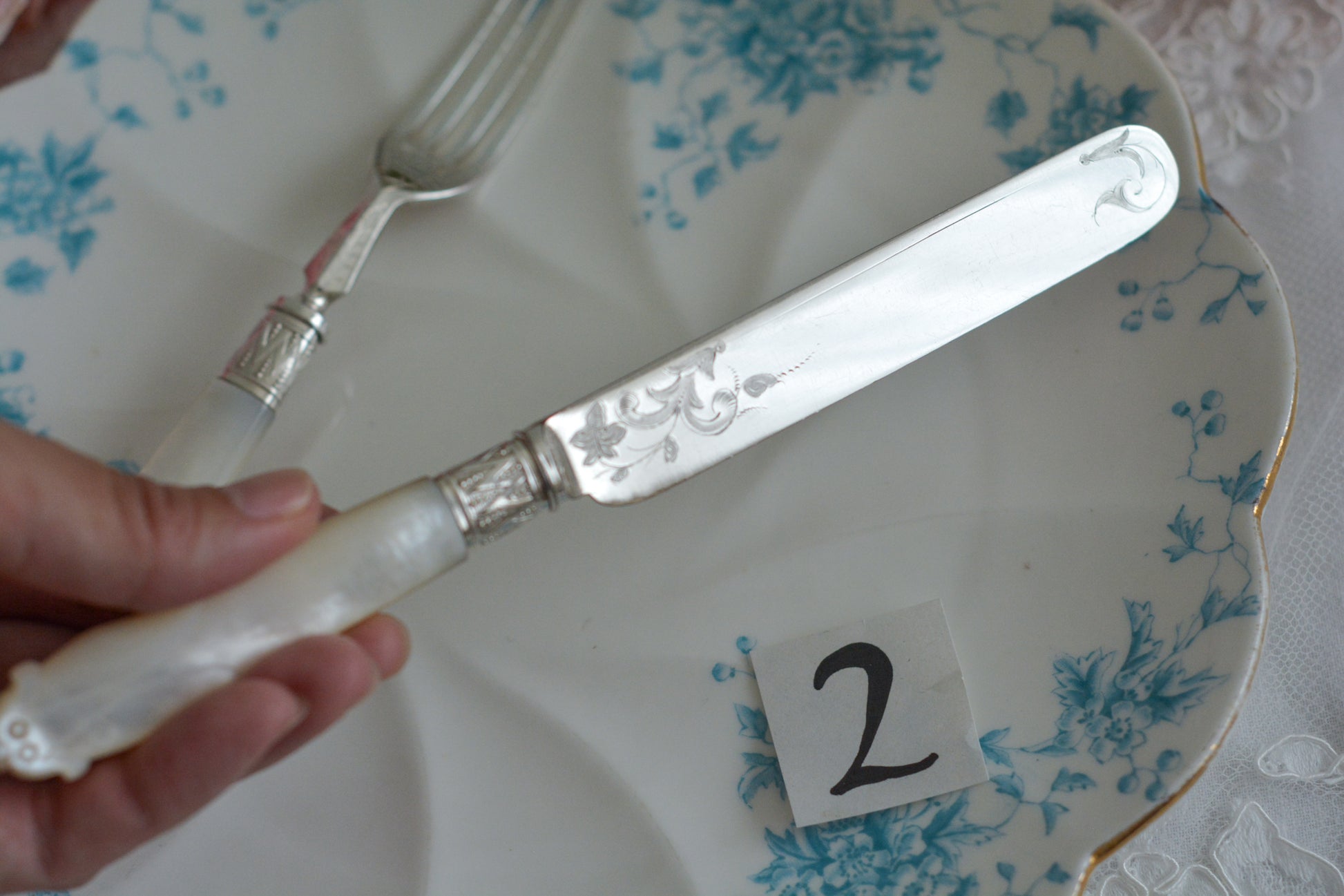 白蝶貝ハンドルと人気の丸刃のカトラリー。こちらは白蝶貝にも手彫りで模様が彫られています。シルバープレートのブレードに少しスレが見られます(状態を考慮した価格になっております)が、白蝶貝の優しい輝きと繊細な模様がとても美しいお品です。こちらは1組(フォークとナイフ2本セット)からご購入いただけます。①〜③からお選びください。