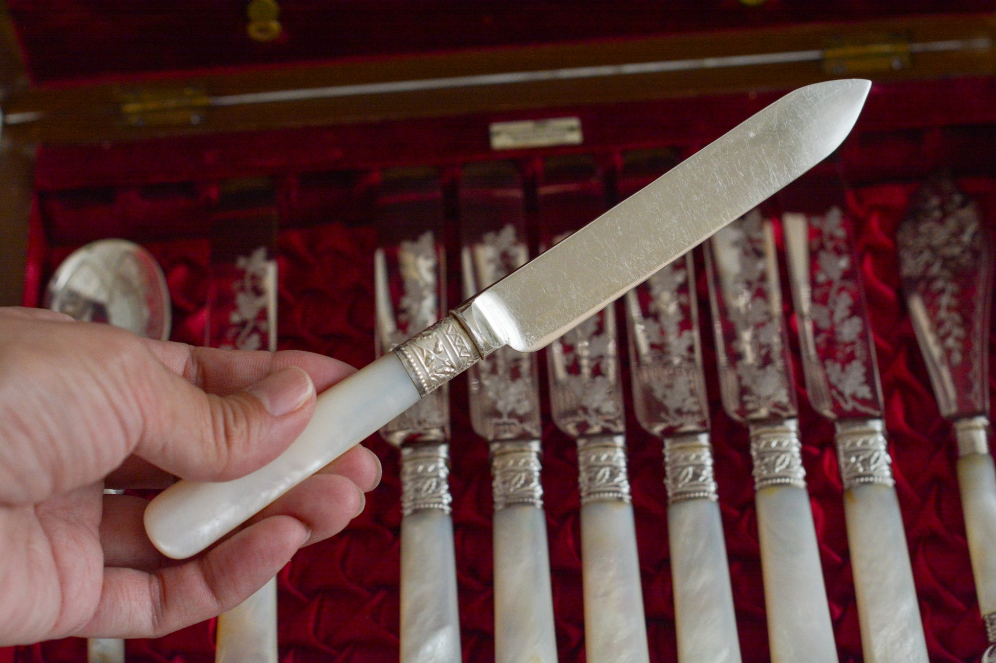 オークの木箱に入った白蝶貝ハンドルのカトラリーセット。元はフォーク&ナイフ12組のセットだったと思いますが今は8組のセットになっていて、同じシリーズではありませんが、サービングスプーンとサービングナイフがセットに加えられています。繊細な彫刻と白蝶貝の優しい輝きがとても美しいセットです。白蝶貝もたっぷりと使われていて贅沢なお品です。