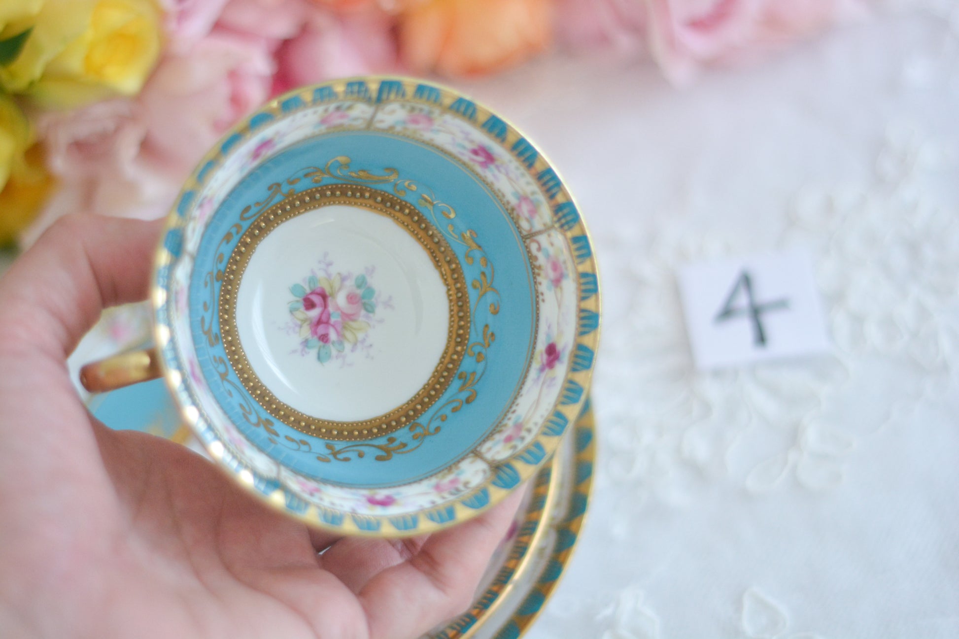 L&COという日本のメーカーのアンティーク里帰り品です。美しいターコイズブルーに金盛りの金彩、ハンドペイントで描かれた可憐なバラが上品なお品。1800年代後半頃からノリタケをはじめ日本からたくさんのメーカーが英国やアメリカに陶磁器を輸出していました。L&COは英国の老舗デパートリバティで販売されていたと言われています。キラキラしたティーセットがデパートに並べられている風景は、当時の人々の目と心を楽しませていたことでしょう。オールドニッポンの美しいティーカップでティータイムをお楽しみください。