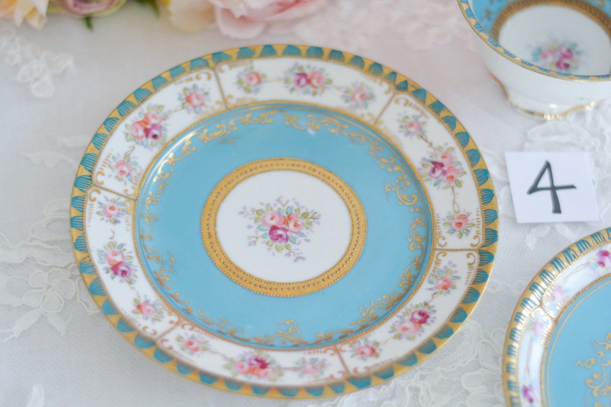 L&COという日本のメーカーのアンティーク里帰り品です。美しいターコイズブルーに金盛りの金彩、ハンドペイントで描かれた可憐なバラが上品なお品。1800年代後半頃からノリタケをはじめ日本からたくさんのメーカーが英国やアメリカに陶磁器を輸出していました。L&COは英国の老舗デパートリバティで販売されていたと言われています。キラキラしたティーセットがデパートに並べられている風景は、当時の人々の目と心を楽しませていたことでしょう。オールドニッポンの美しいティーカップでティータイムをお楽しみください。