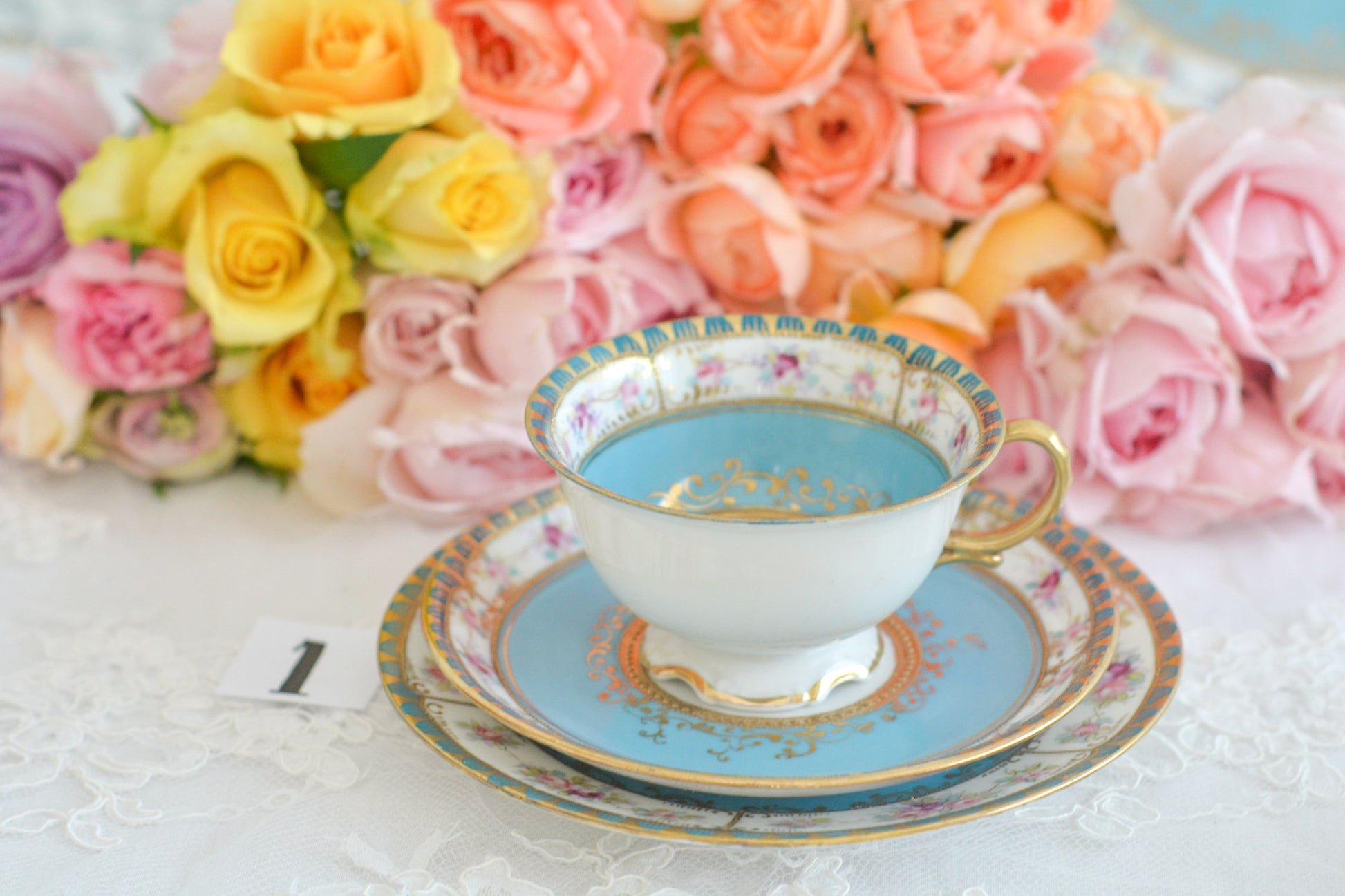 L&COという日本のメーカーのアンティーク里帰り品です。美しいターコイズブルーに金盛りの金彩、ハンドペイントで描かれた可憐なバラが上品なお品。1800年代後半頃からノリタケをはじめ日本からたくさんのメーカーが英国やアメリカに陶磁器を輸出していました。L&COは英国の老舗デパートリバティで販売されていたと言われています。キラキラしたティーセットがデパートに並べられている風景は、当時の人々の目と心を楽しませていたことでしょう。オールドニッポンの美しいティーカップでティータイムをお楽しみください。