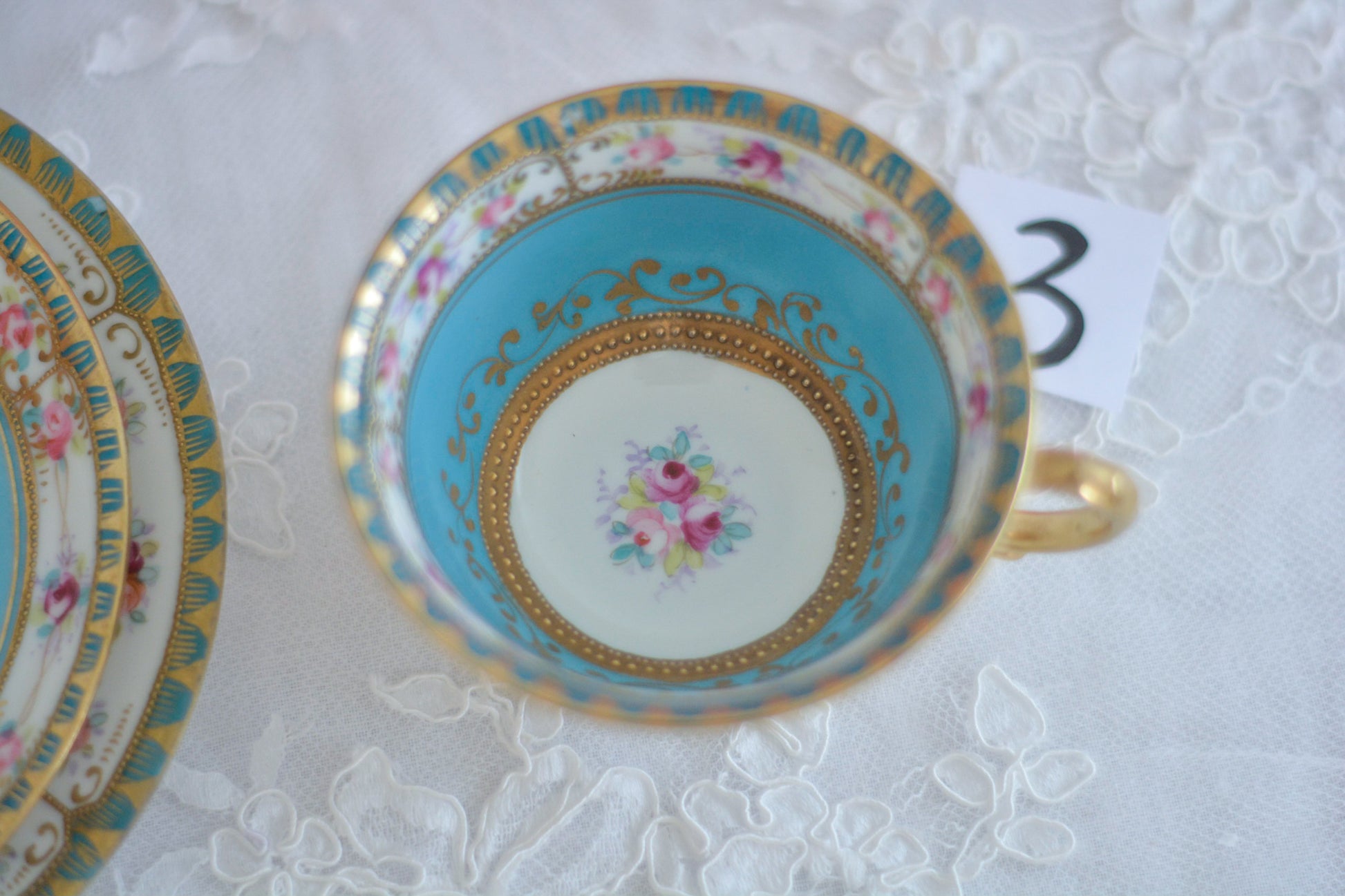 L&COという日本のメーカーのアンティーク里帰り品です。美しいターコイズブルーに金盛りの金彩、ハンドペイントで描かれた可憐なバラが上品なお品。1800年代後半頃からノリタケをはじめ日本からたくさんのメーカーが英国やアメリカに陶磁器を輸出していました。L&COは英国の老舗デパートリバティで販売されていたと言われています。キラキラしたティーセットがデパートに並べられている風景は、当時の人々の目と心を楽しませていたことでしょう。オールドニッポンの美しいティーカップでティータイムをお楽しみください。